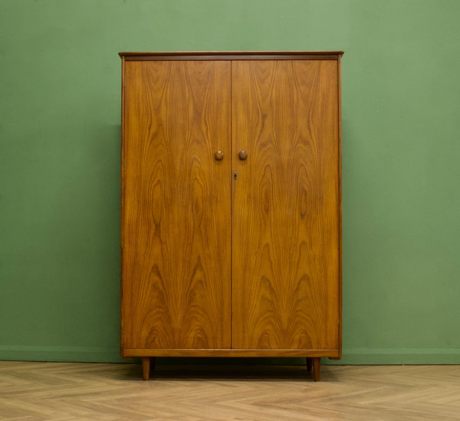 A walnut freestanding wardrobe by Butilux - circa 1960s
Internally there is are two rails and a shelf
The attractive legs are slightly tapered and the handles are solid wood - complete with a working lock (new replacement)


This wardrobe can be