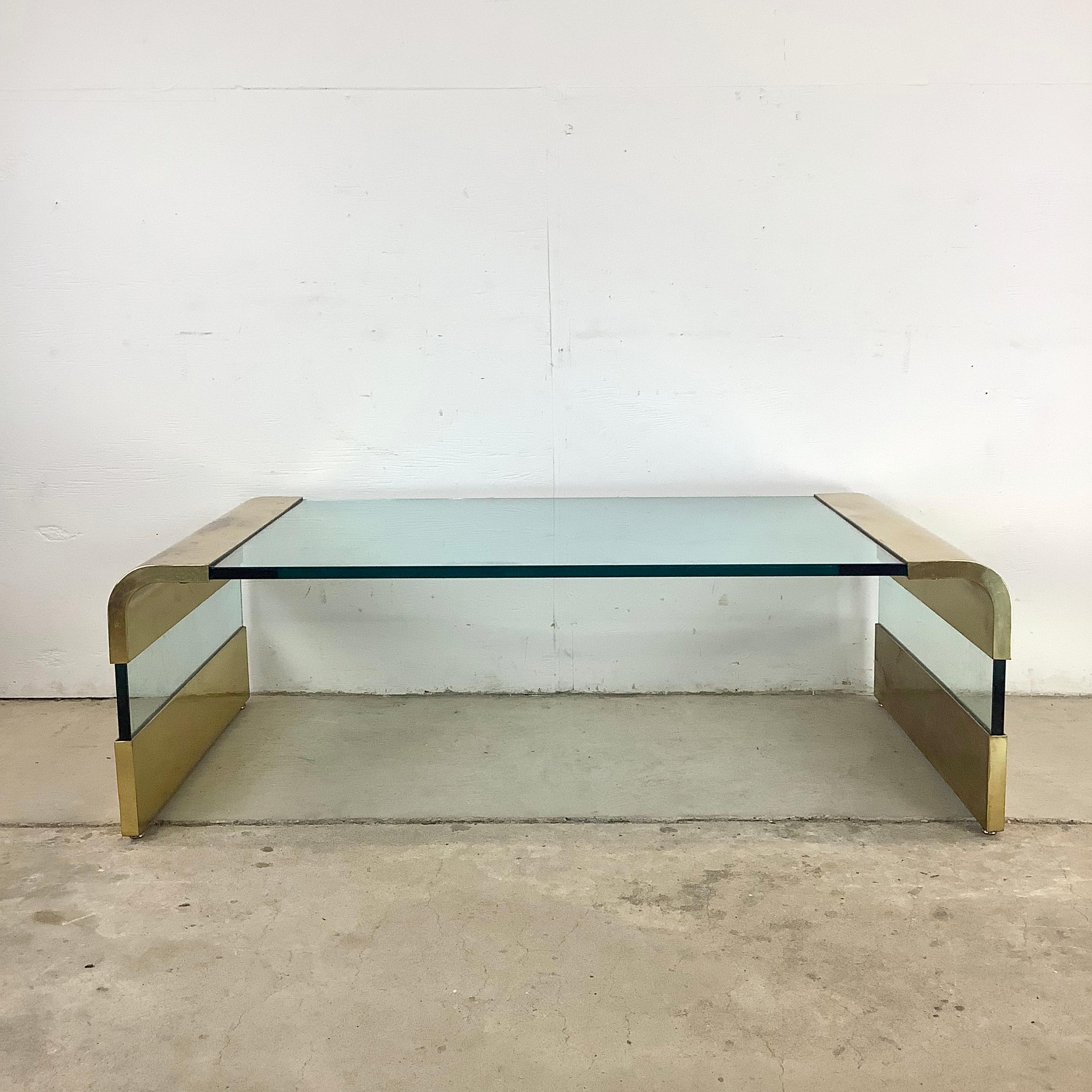 Sleek, sophisticated, and effortlessly modern, this Pace coffee table is a timeless example of mid-century design. Constructed with a thick, beveled glass top and finished with brass-accented edges, this table strikes a perfect balance between