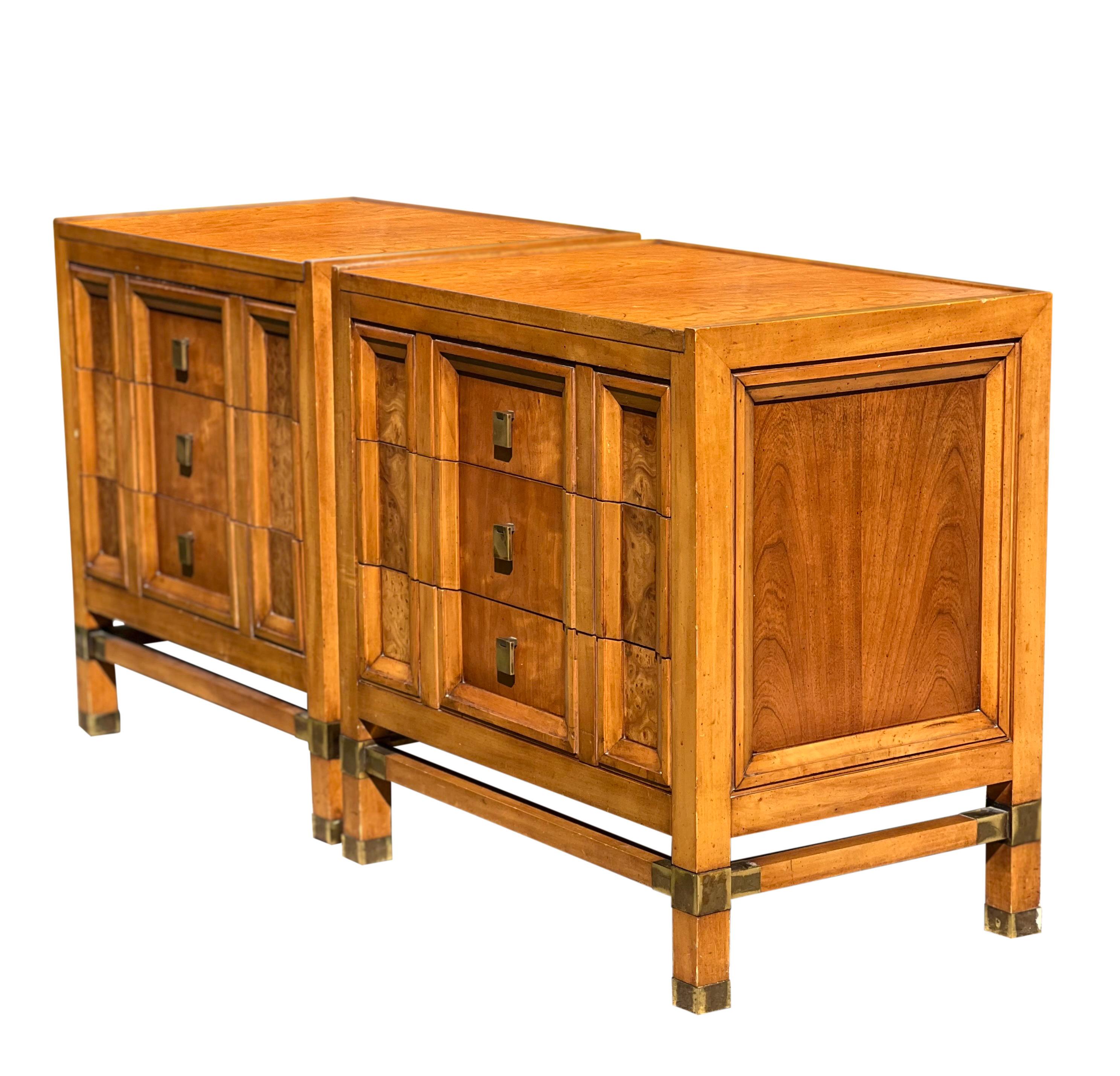 Exceptional pair of mid-century Mastercraft style nightstands by J.L. Metz. 

The stands are weathered cherry with lovely burl accent panels. They feature three clean, dovetail drawers with rectangular brass drop pulls. Unique brass detail on the