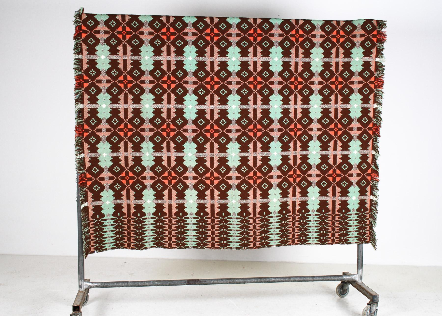 A single size Welsh wool tapestry blanket measuring 244cm (96″) x 168cm (66″)+fringe
Known for their exceptional quality and craftsmanship, this example has an earthy brown and green colourway with hues of pale reds and salmon-pink, creating a warm