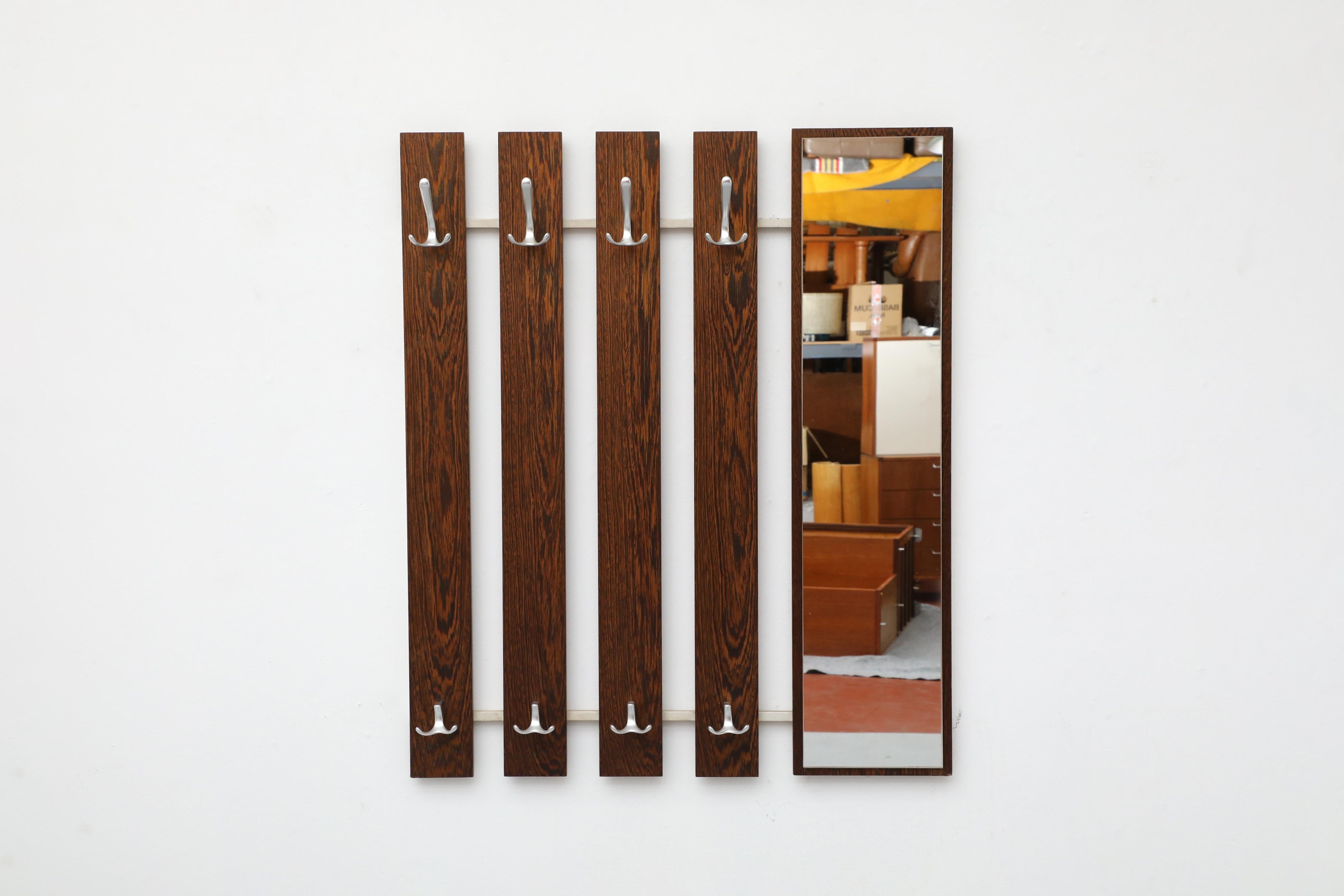 Elegant Mid-Century wall mount coat rack perfect for an entry way or closet space. Exotic Wenge wood slats with aluminum hooks paired with a tall rectangular mirror on a square white enameled metal frame. This piece is a stylish space saving