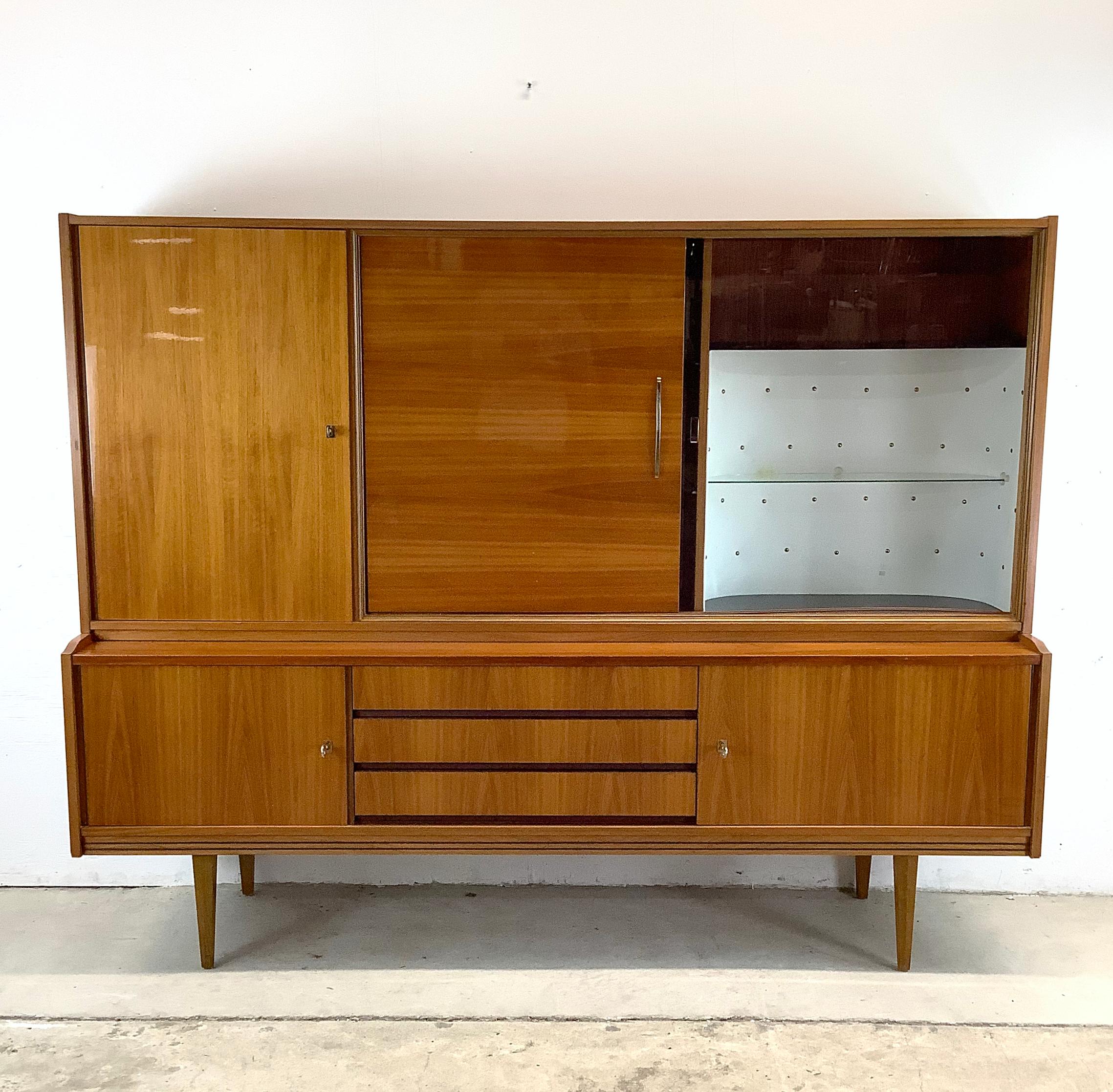Step back into the elegance of the mid-20th century with the Altena 200 by Munker-Modell, a stunning mid-century buffet with bar cabinet that embodies the sleek sophistication of the era. This exquisite piece is more than just a cabinet; it's a