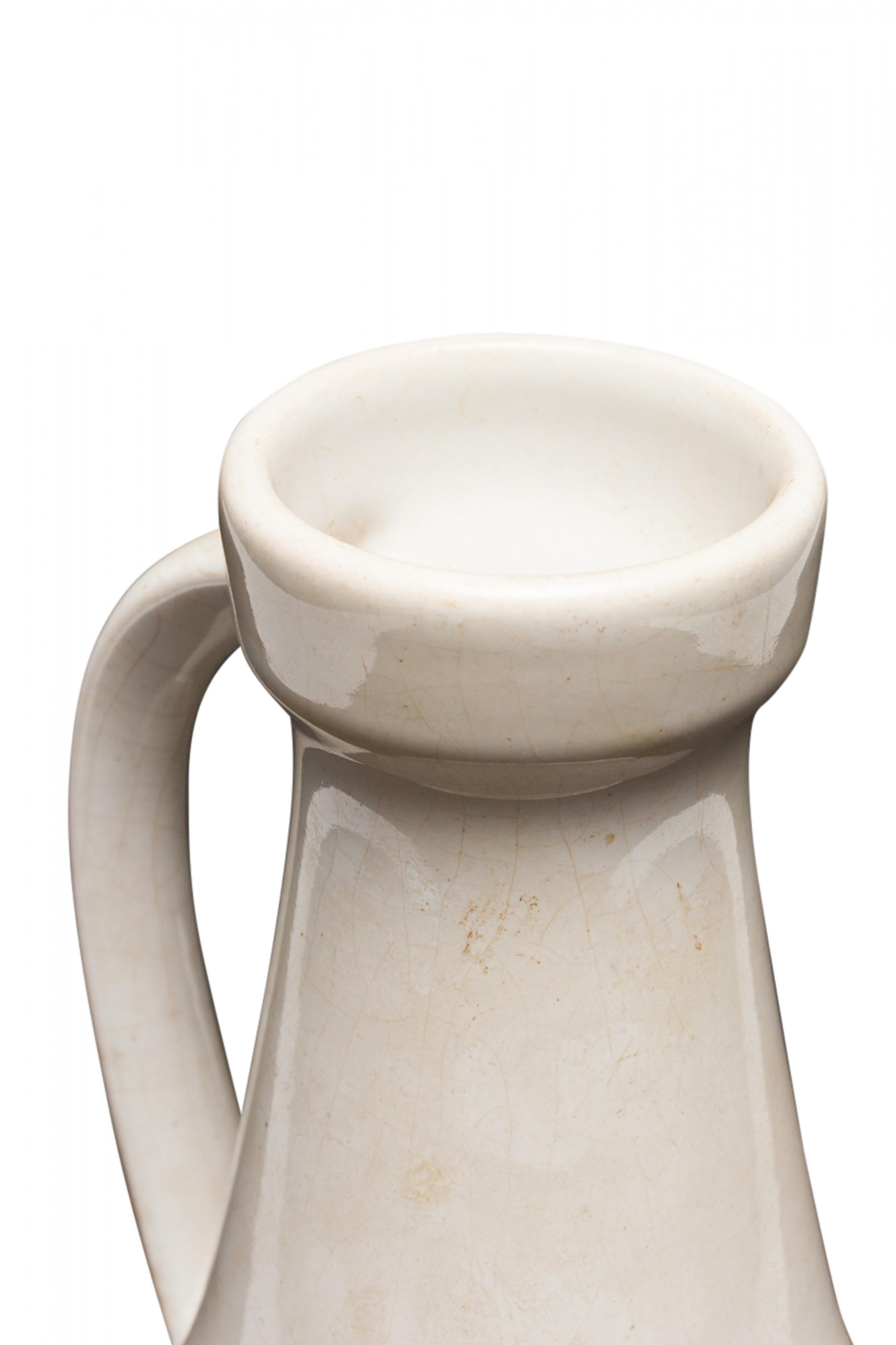 West German Mid-Century ceramic handled vase with a dimpled band around the bottom and a tapered neck and curved handle with a white glazed finish. (mark on bottom, W. GERMANY 862/20).