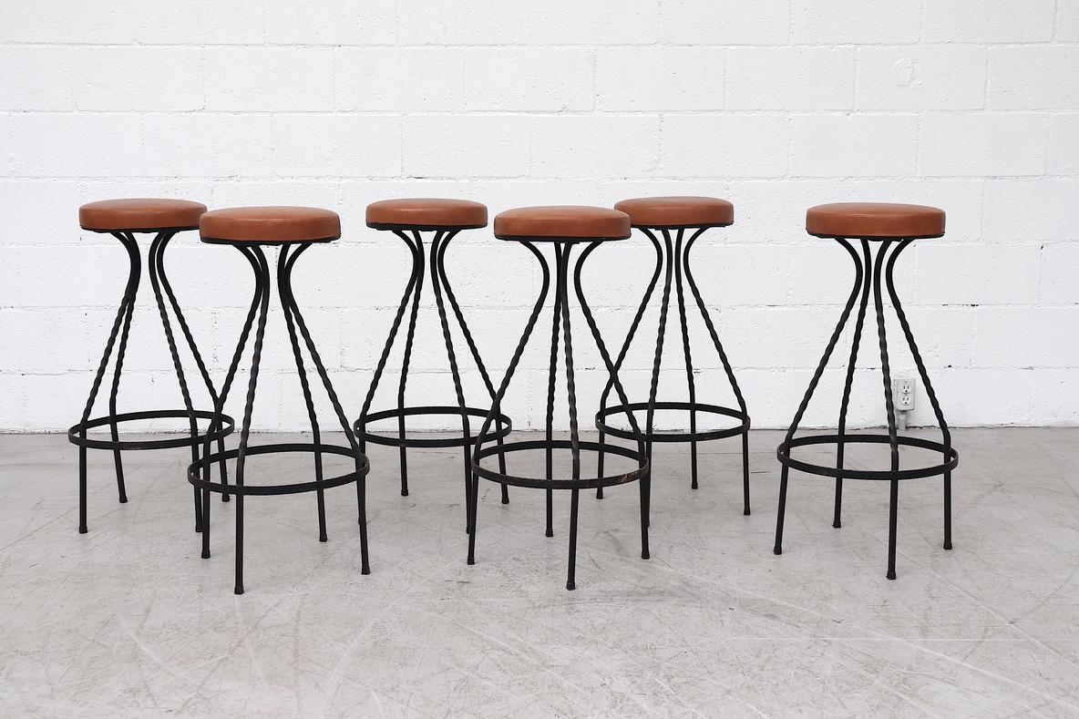 Amazing, Frederic Weinberg Style, Mid-Century western style Brutalist bar stools. These stools have padded faux leather upholstered seats on twisted black wrought iron legs. Foot rest is 9