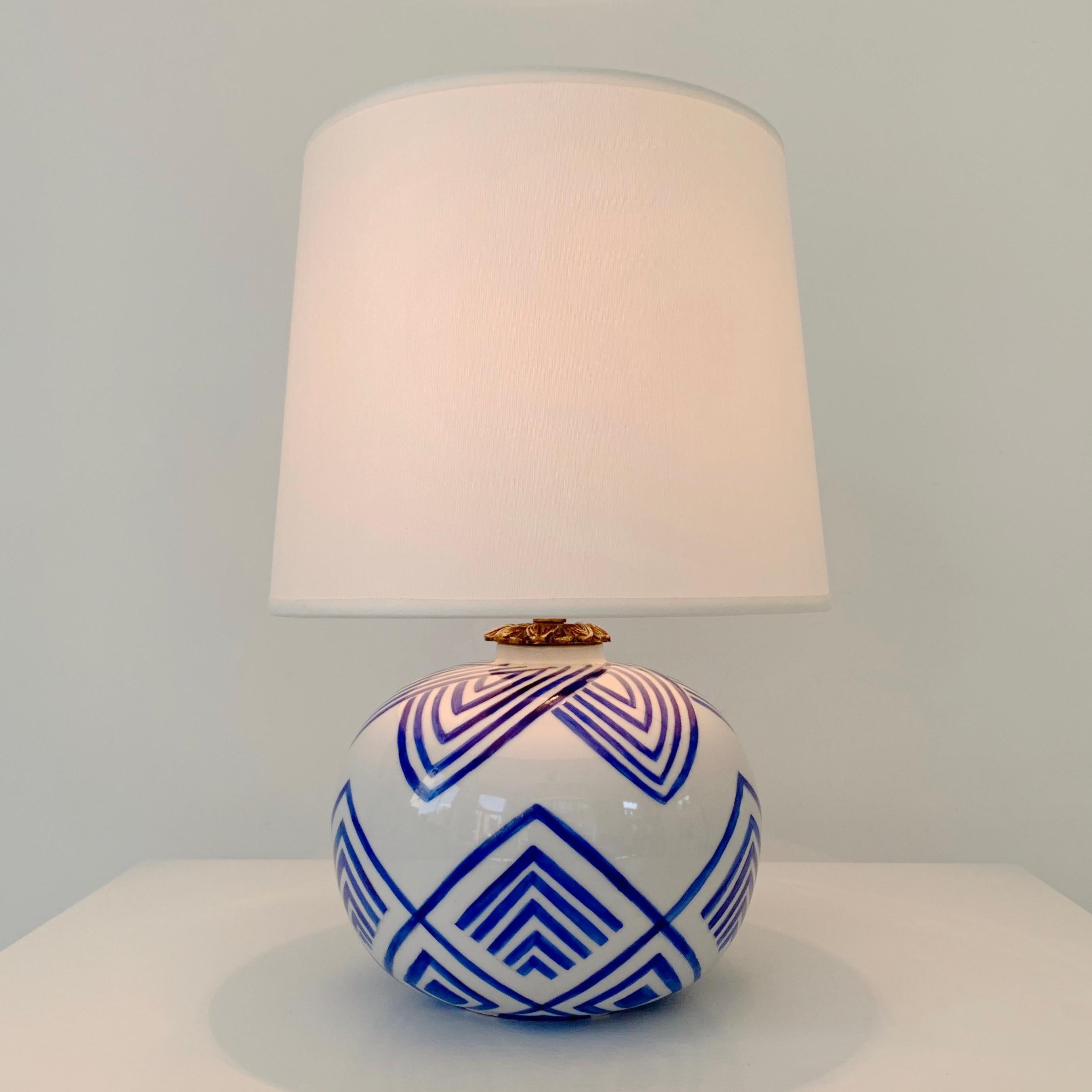 Decorative Art Deco table lamp, 1929, France.
White enameled earthenware with lumiunous blue geometrical hand-made decor.
Rewired. One E 27 bulb.
New white fabric.
Signed underneath H.Gerard 1929.
Good condition.
H.T. 30cm,  ceramic only H.