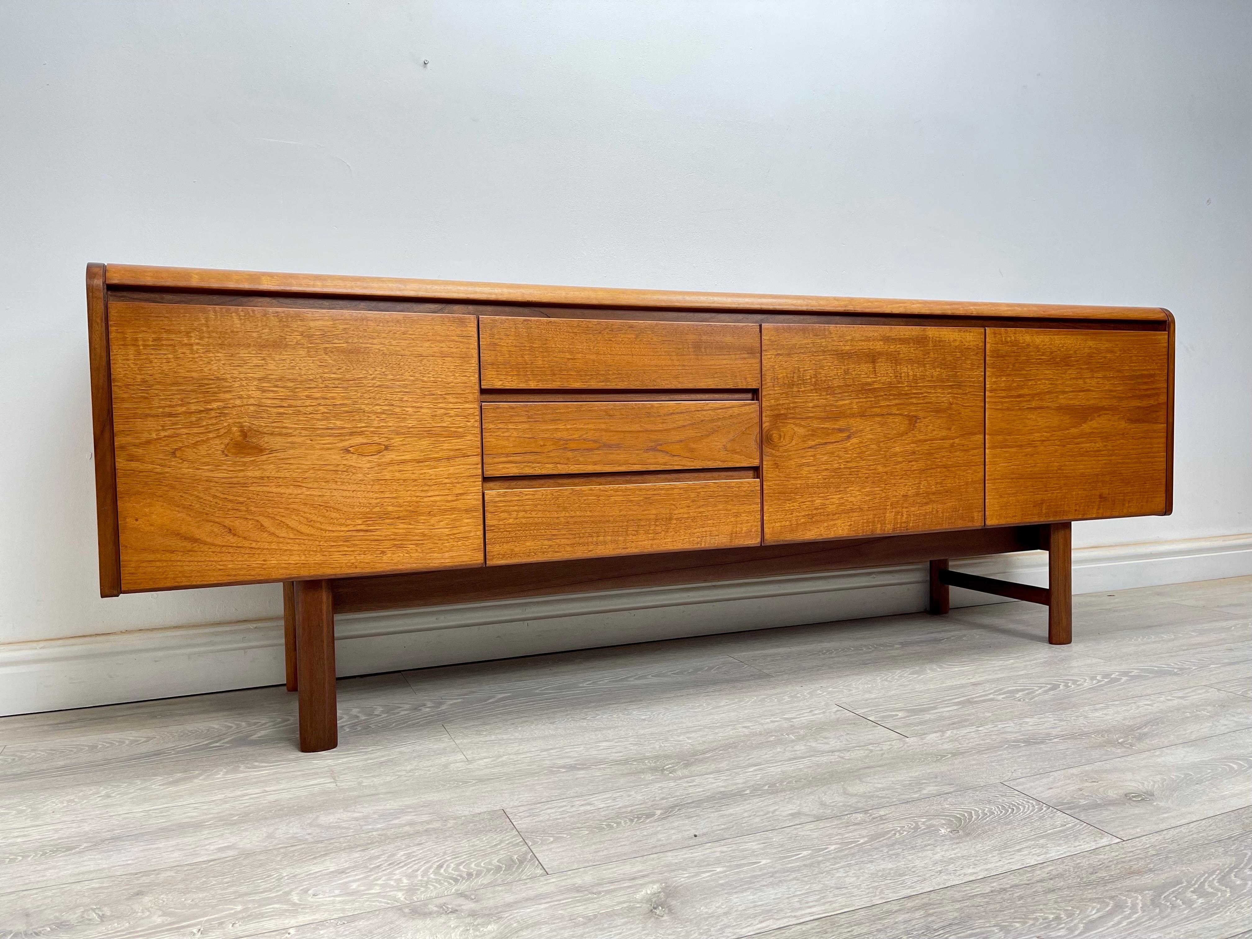 SIDEBOARD 
midcentury teak sideboard made by White and Newton circa 1960s. The sideboard has stunning grain throughout, great quality piece with Minimalist design and plenty of storage. The sideboard has a double cupboard with a fixed shelf, bank of