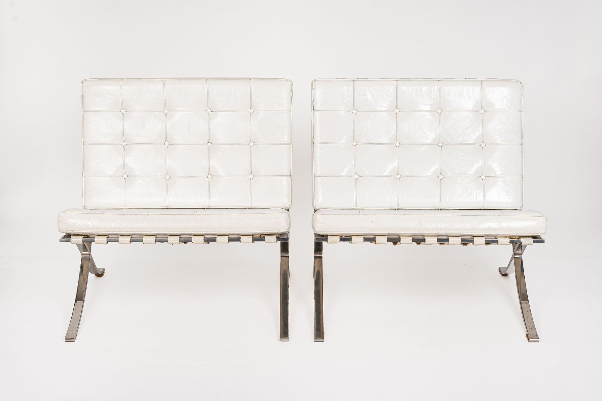 This pair of vintage mid century modern white Barcelona chairs designed by Mies van der Rohe were manufactured by Knoll International, Inc. circa 1970. This iconic Bauhaus chair originally designed by Ludwig Mies van der Rohe in 1929 for the