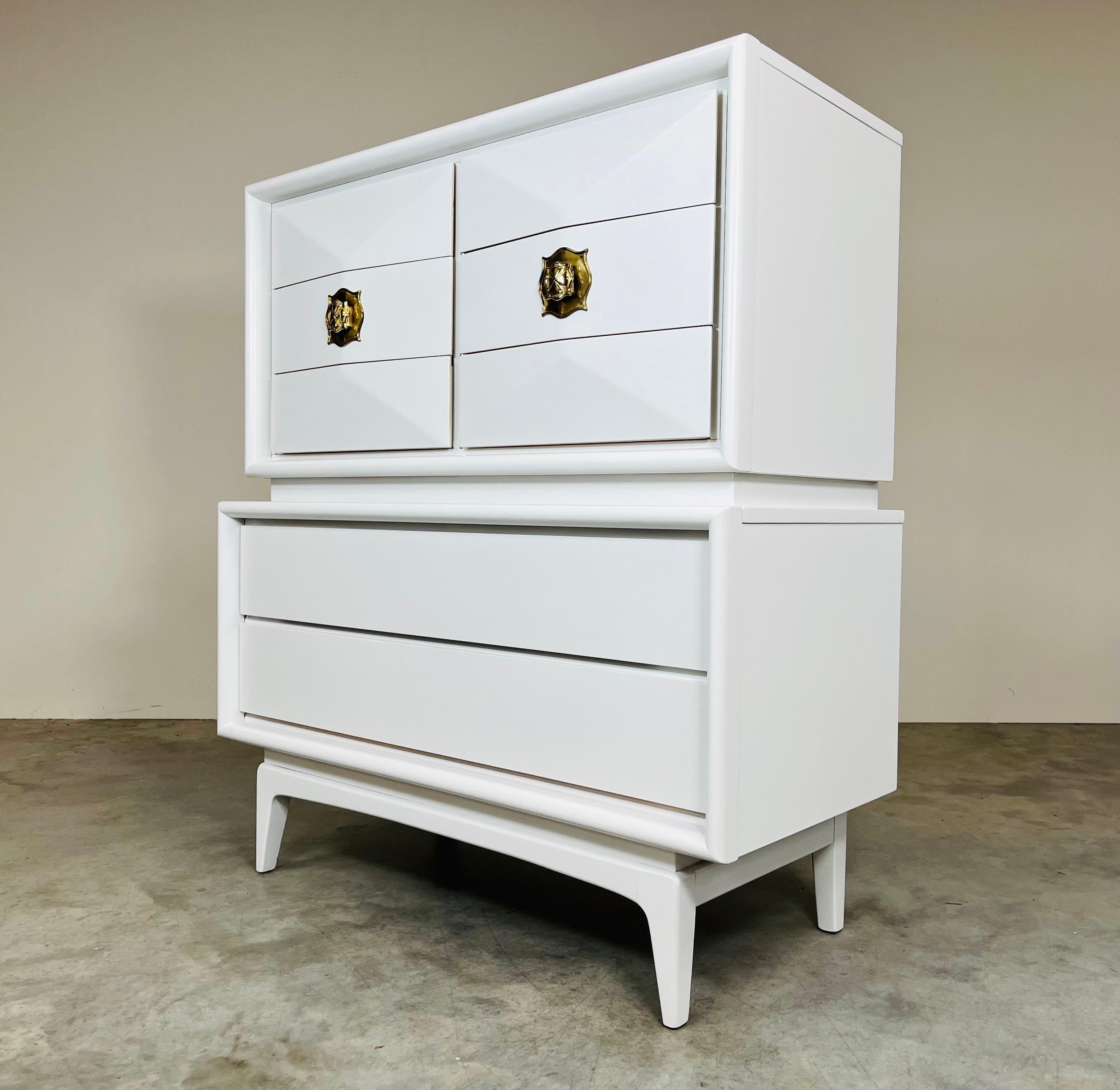 A stunning mid-century modern 8-drawer gentleman’s chest having sculptural convex diamond front top drawers with brass pulls and 2 flat wide bottom drawers raised on a base with four tapered legs.
In outstanding vintage condition. Cleaned and ready