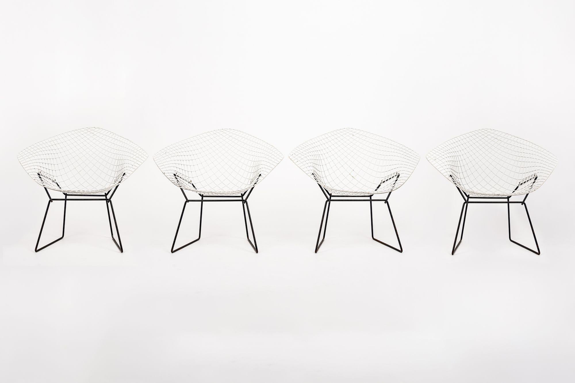 This set of four vintage mid century modern diamond wire lounge chairs designed by Harry Bertoia for Knoll are circa 1970. Originally designed by Bertoia in 1952, the industrial material and sculptural form of this iconic chair has become a fixture