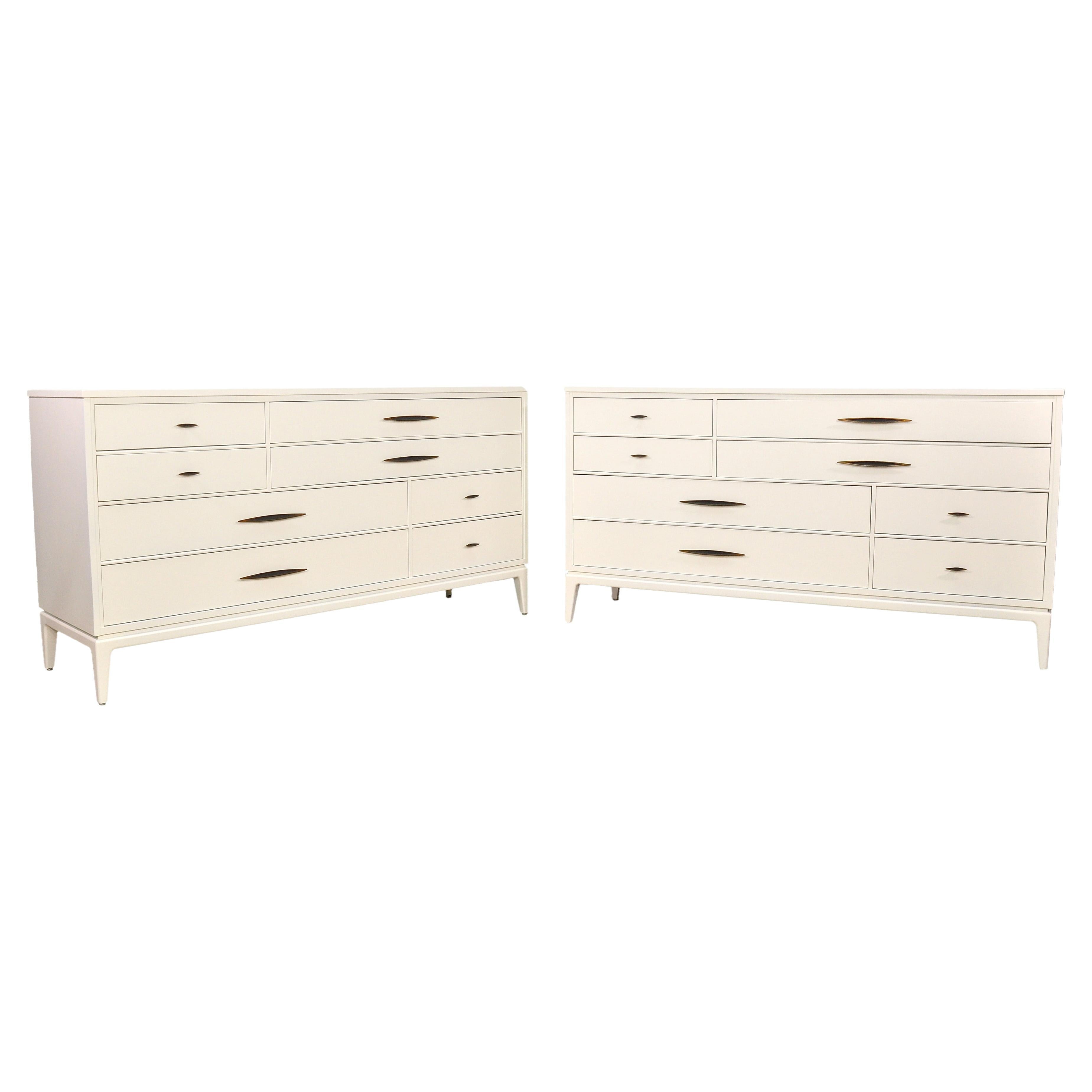 A solid walnut off-white lacquered midcentury modern dresser made by the Davis Cabinet Co. of Nashville, Tennessee. The light ivory cabinet features four (4) large and four (4) smaller drawers (some with dividers) with sleek brass and black faux