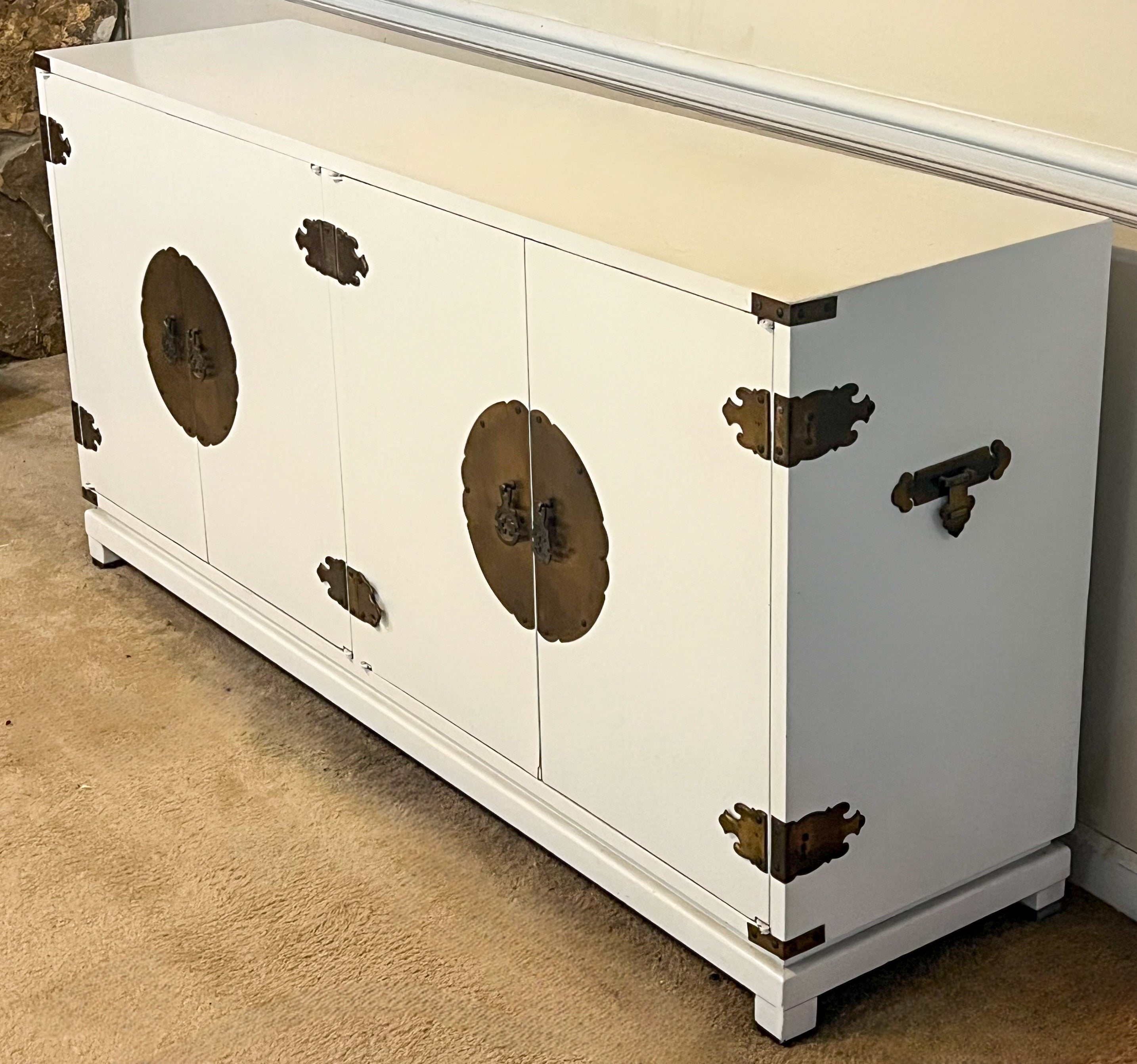 Dies ist eine von James Mont inspirierte Kredenz im Ming-Stil aus der Mitte des Jahrhunderts, weiß lackiert. Er wurde von der Sanford Furniture Company hergestellt. Er hat Füße mit Messingkappen, die auf den Fotos etwas verloren wirken. Es ist weiß