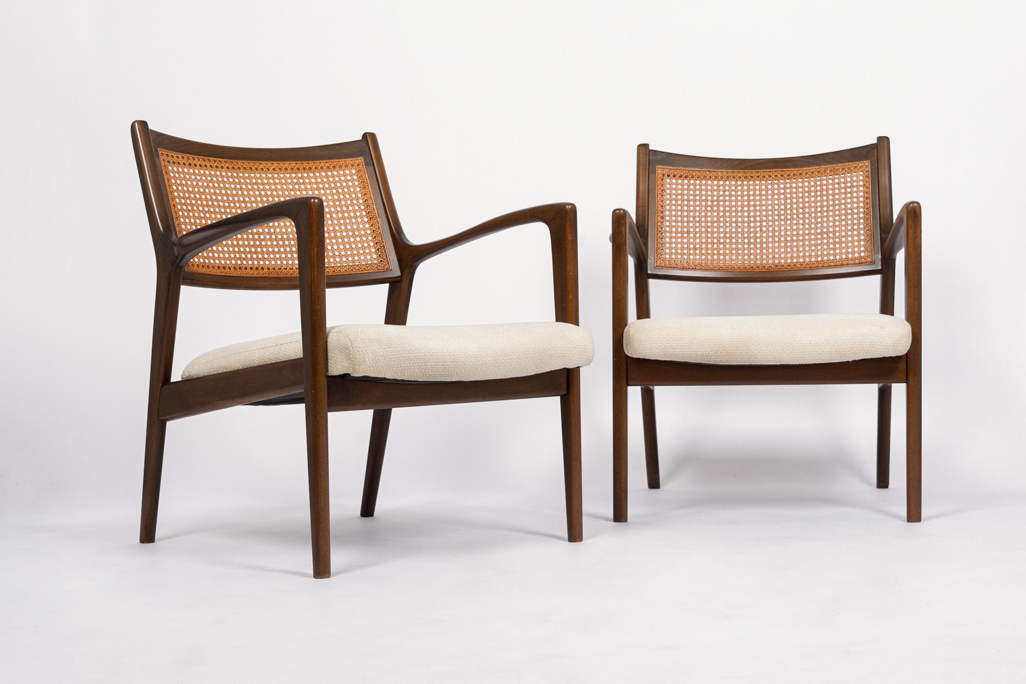 This beautiful pair of vintage mid century modern lounge chairs in the style of Jens Risom are circa 1960. The classic Scandinavian modern design has clean, minimalist lines and elegant curves and a striking sculptural profile. The lounge chairs