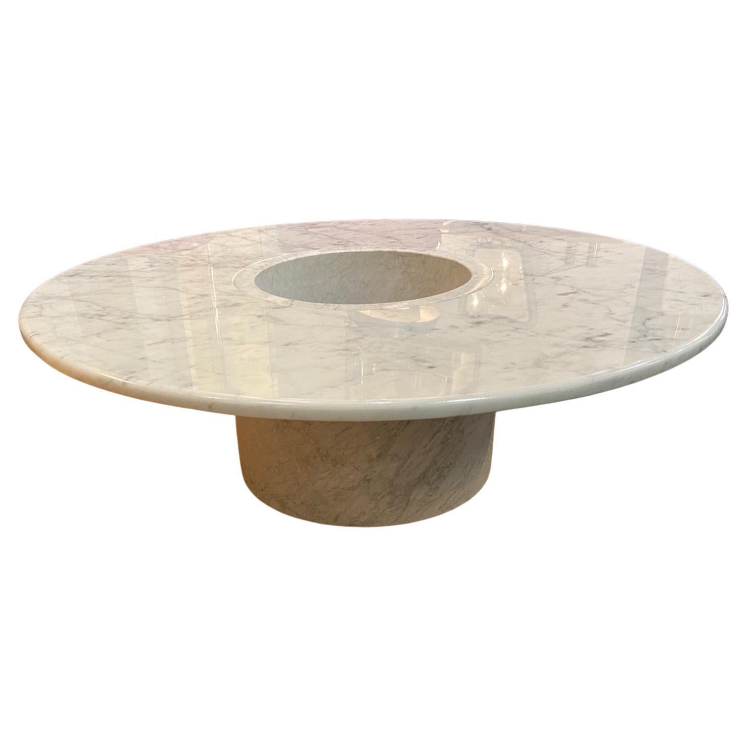 An unusual Italian 1970's circular Carrara marble coffee table with a central hole which could be used for either plants or a champagne bucket etc... It is made of 2 pieces, the supporting cylinder and the circular top. This would reduce the