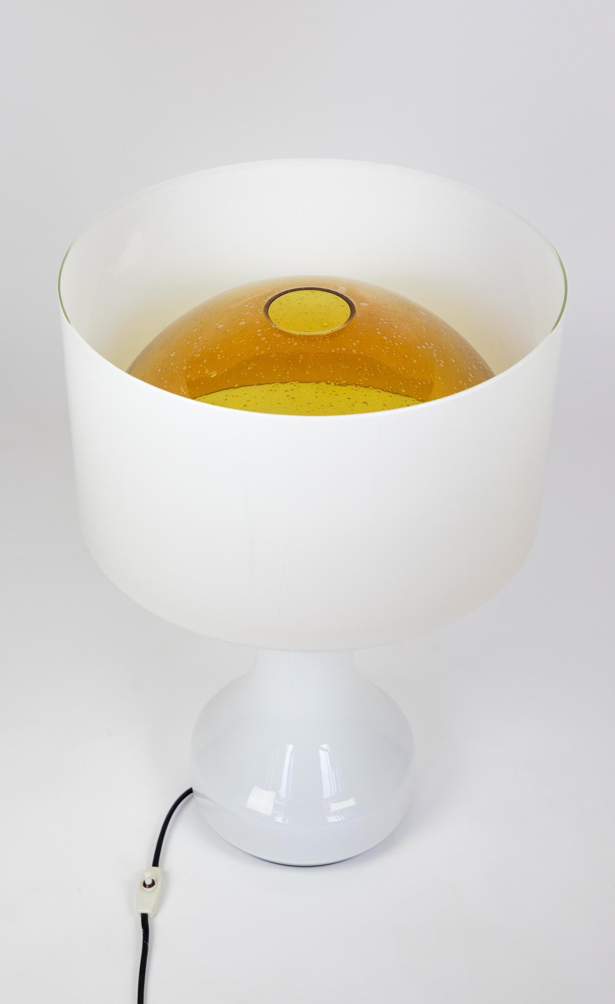Mid Century Modern Murano Glass Table Lamp Sebenica for Vistosi, Italy, 1960s.

This very large Murano glass table lamp has a wonderful shape. The yellowy amber hemisphere inside the lamp lends a great contrast to the white shell and has small air