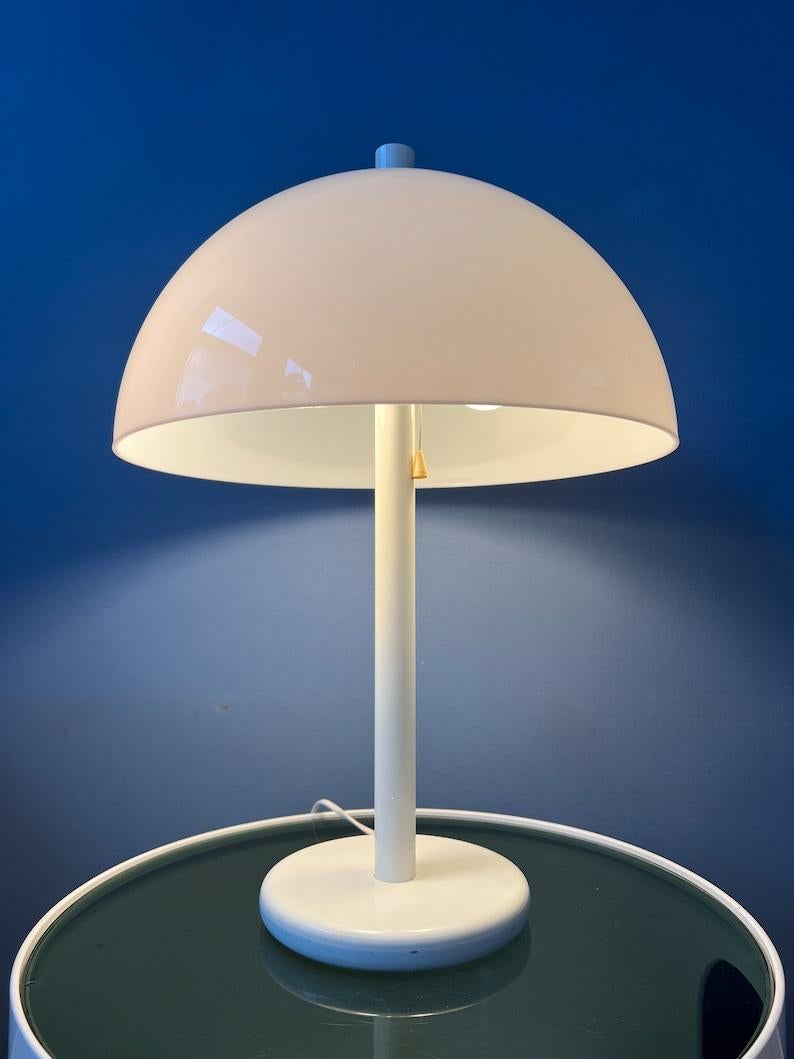 Lampe de table Dijkstra de l'ère spatiale, de couleur blanche, avec abat-jour en forme de champignon. L'abat-jour en verre acrylique blanc produit une lumière agréable et chaleureuse. La lampe nécessite une ampoule E27/26 (standard) et dispose