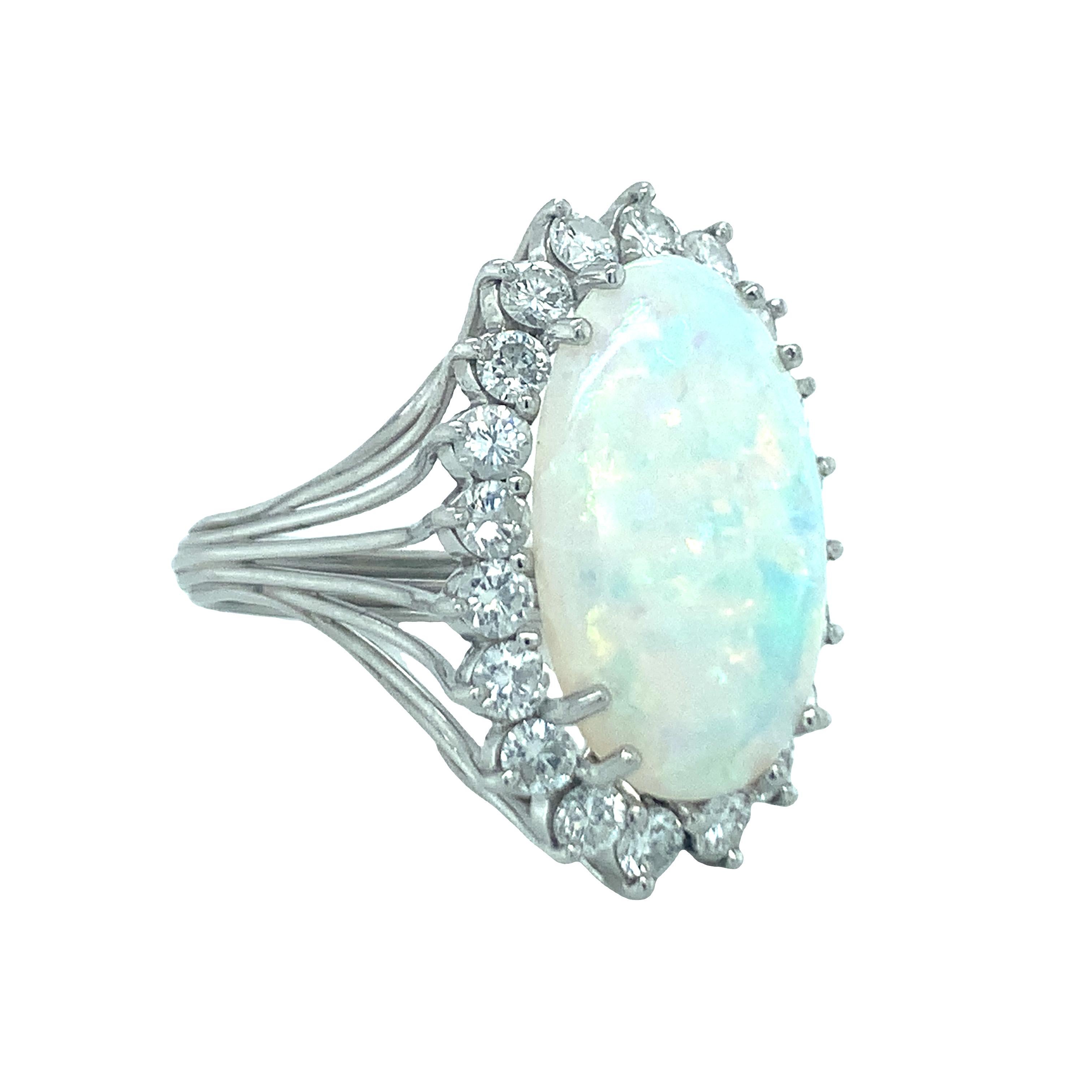 One mid-century white opal and diamond platinum ring centering one oval cabochon white opal weighing 5.75 ct. surrounded by twenty round brilliant cut diamonds weighing 1.25 ct. with G-H color and SI-1 clarity. Circa 1950s.

Vibrant, dancing,