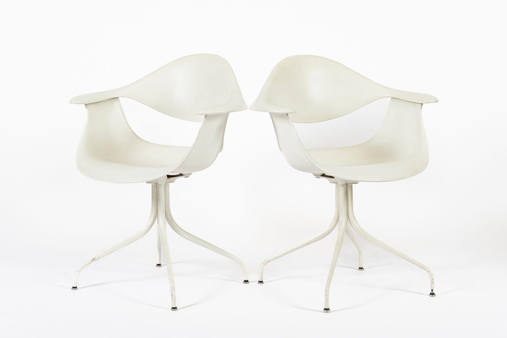 These classic mid century modern white “Swag” chairs were designed by George Nelson in 1958 and produced by Herman Miller circa 2010. The iconic mid century design features clean lines and elegant, sculptural curves. The swag leg chair designs by