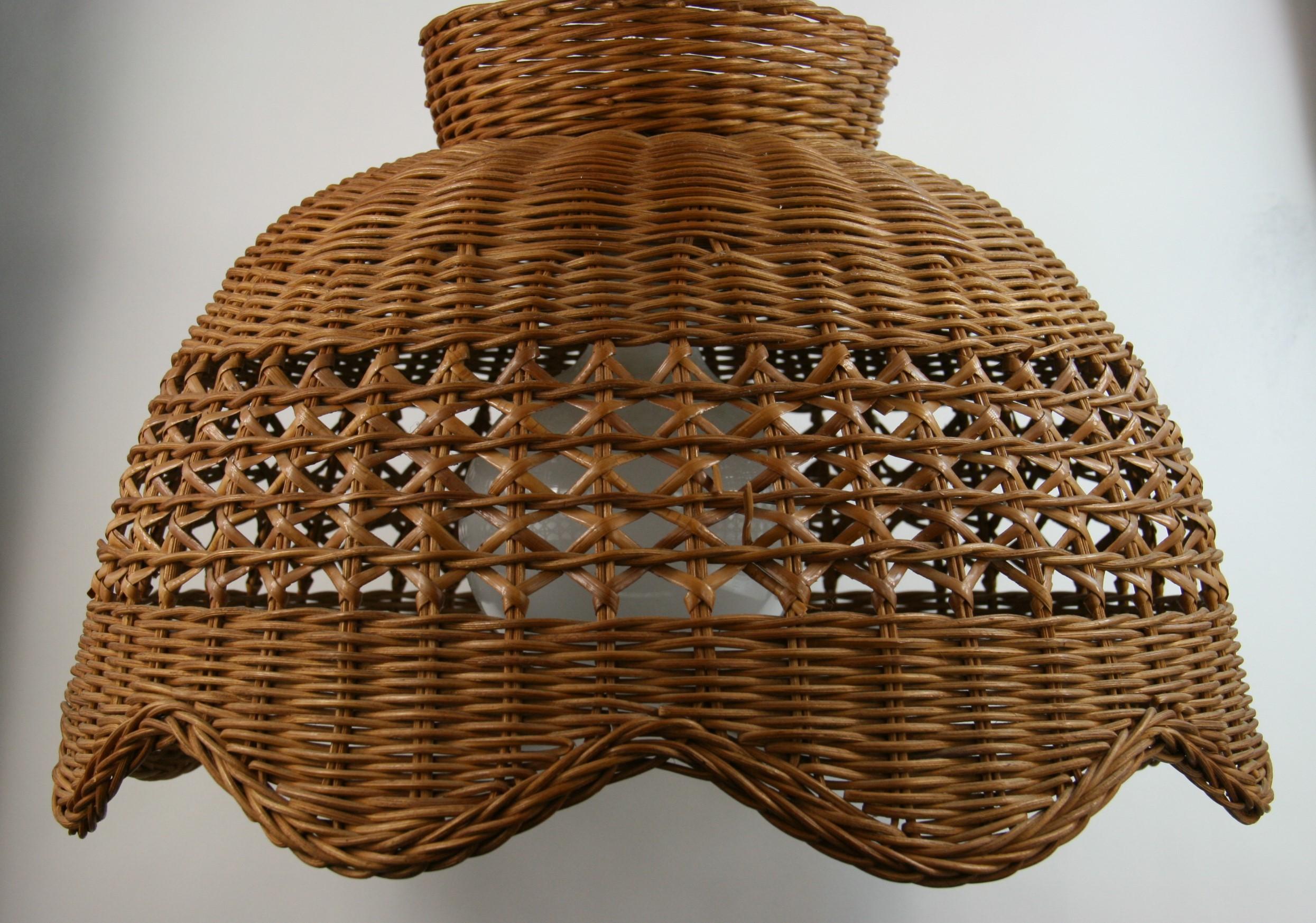 8-276 handwoven rattan  wicker with undulating bottom.
Takes one 100 watt bulb
Supplied with brass chain and canopy
Rewired.