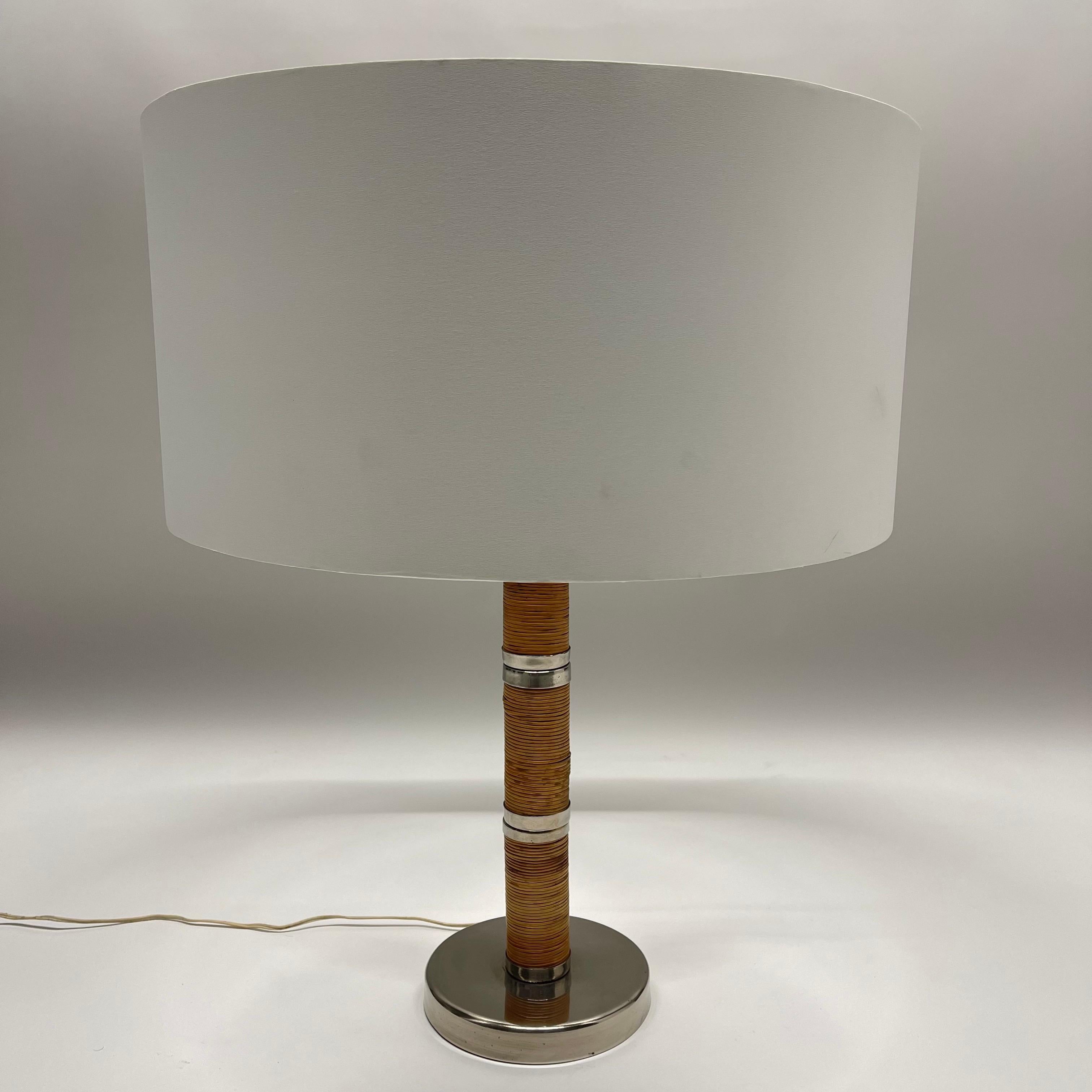 Lampe de table du milieu du siècle, en rotin tressé à la main, avec des accessoires en laiton chromé, dans le style de Paavo Tynell, Italie, vers 1970.

L'abat-jour est utilisé à des fins de présentation uniquement.