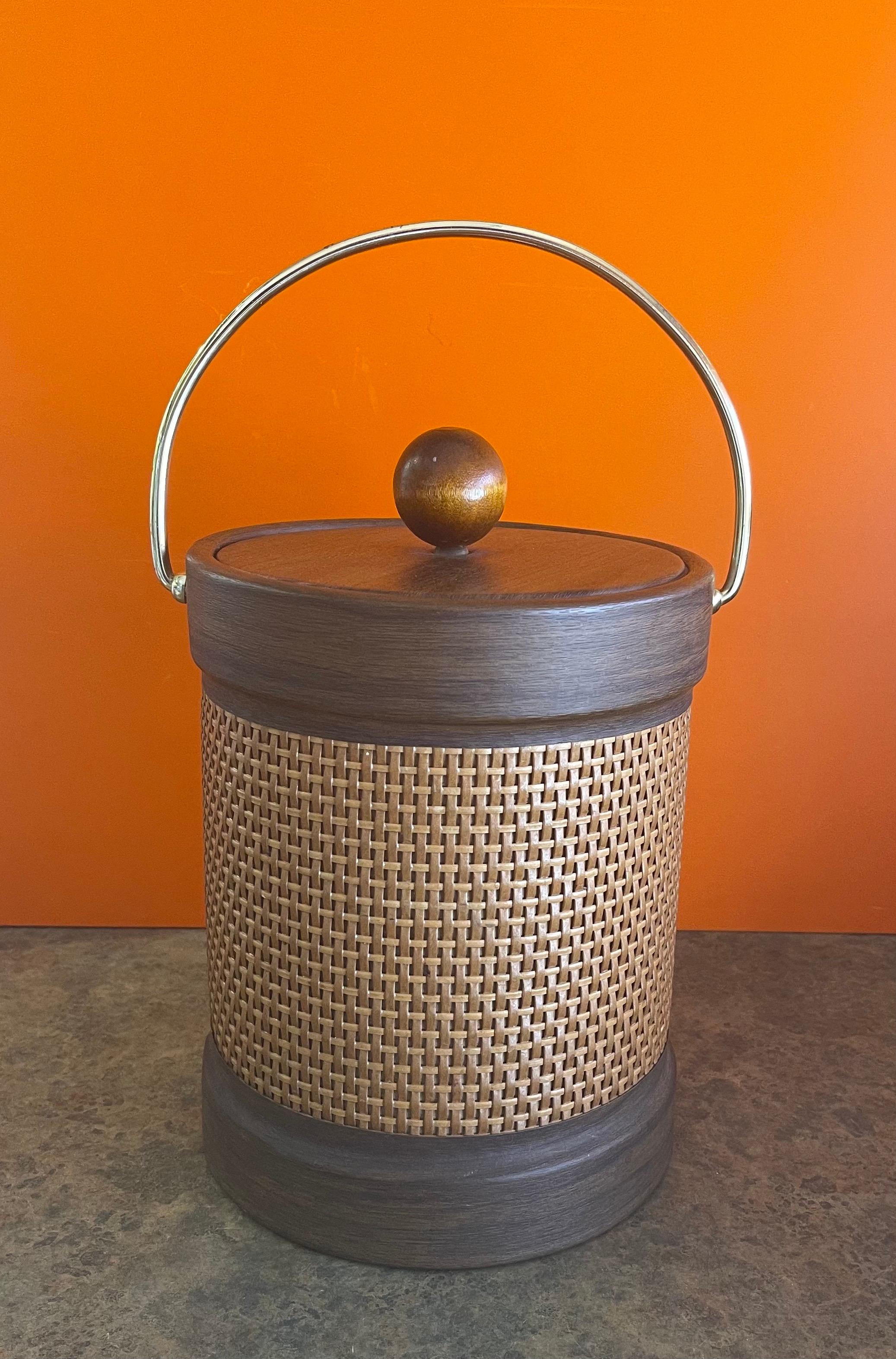 A very nice mid-century wicker wrapped ice bucket with handle by Georges Briard, circa 1970s. The piece is in very good condition and measures 8.5