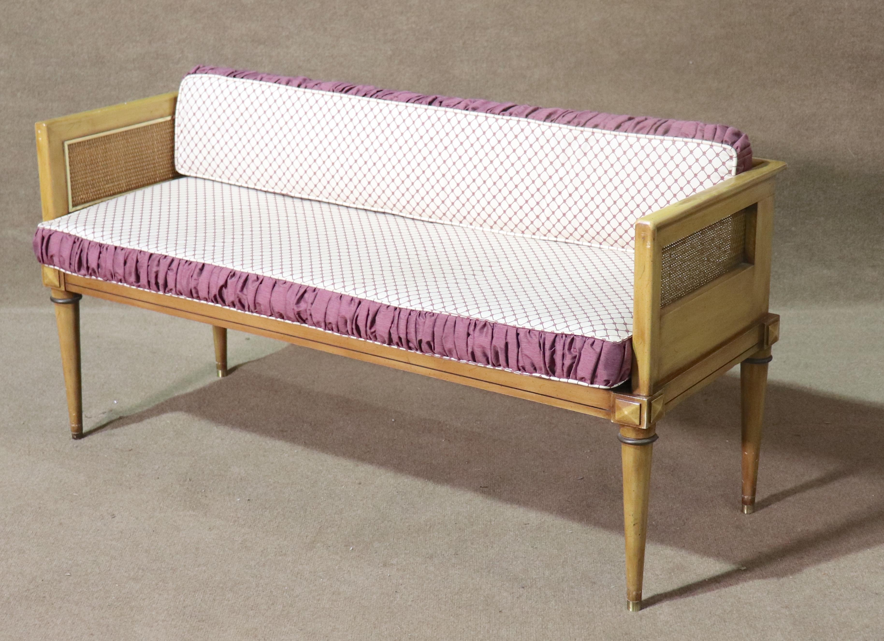 This four foot wide settee features tight woven rattan on both arms and back. The legs are pointed with brass caps, and the cushions feature a ruffled trim.
Please confirm location NY or NJ