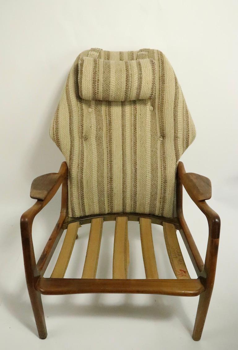 Sculptural walnut framed lounge chair with upholstered seat and back. This example will need restoration, as the finish is worn, as is the upholstery, it is structurally undamaged and is restorable, but again, selling as is as found.
Measures: