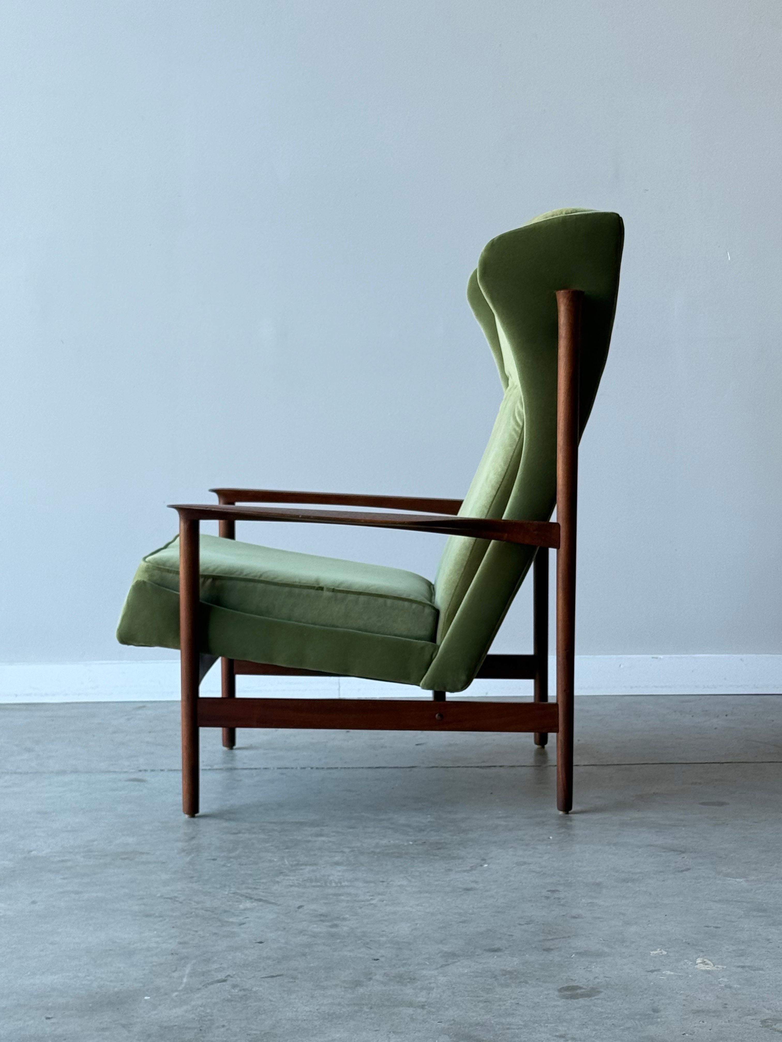 Mid-century wingback armchair designed by Ib Kofod Larsen, circa 1950s, Denmark. This lounge is absolutely stunning with massive sculptural appeal. The frame steals the show, made from teak, and in classic Danish approach - features subtle and well
