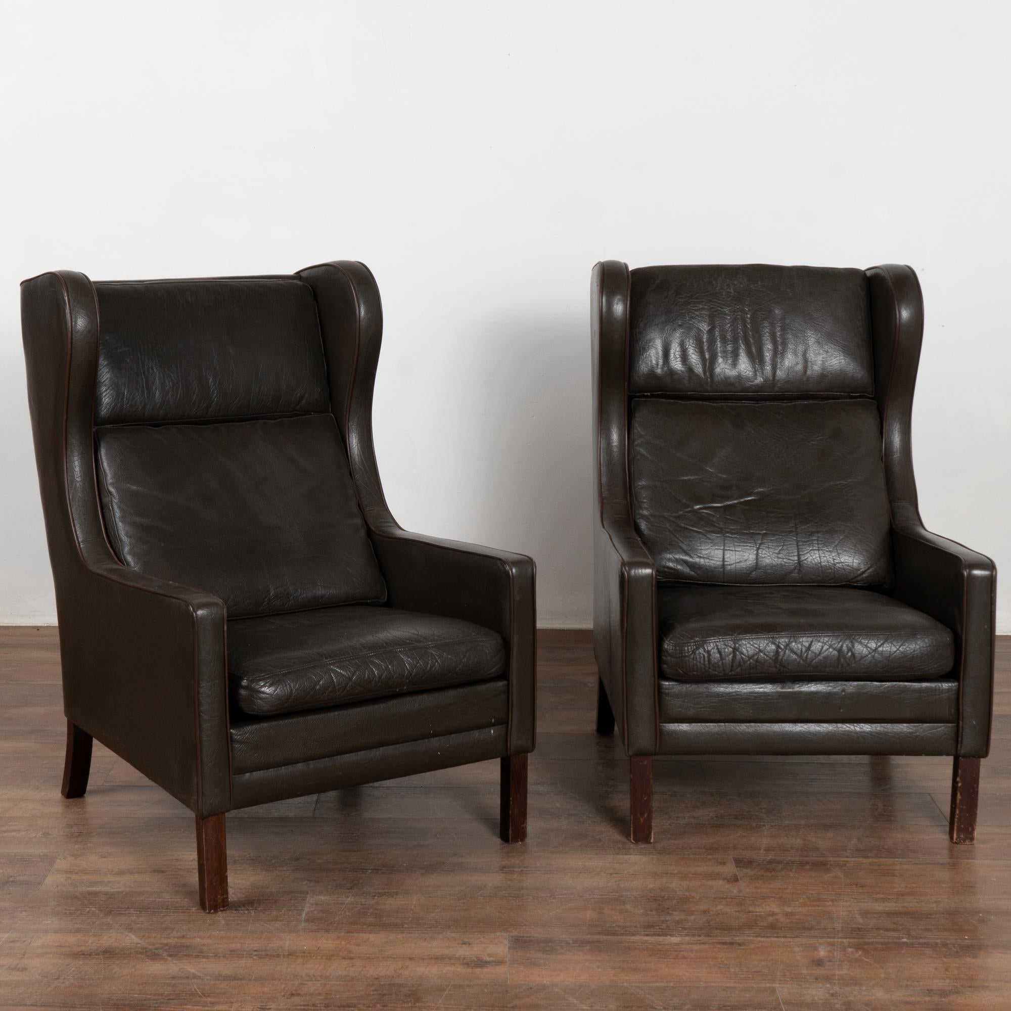 Paar moderne Ohrensessel aus der Mitte des Jahrhunderts aus Dänemark.
Dunkelbraunes Vintage-Leder mit losen Sitz- und Rückenkissen und Beinen aus massivem Buchenholz.
Verkauft in einem soliden, gebrauchten Zustand; das Leder weist Kratzer,
