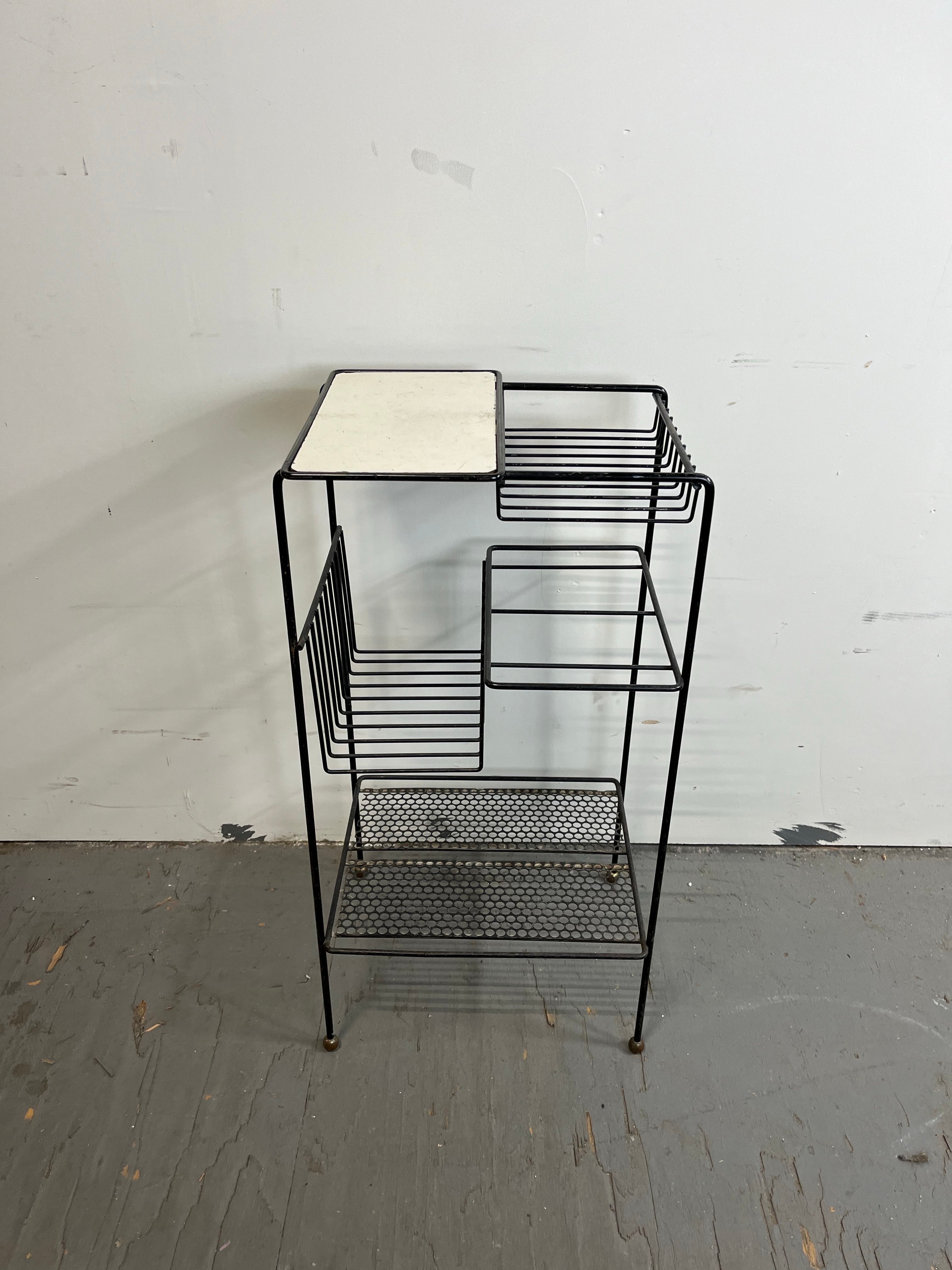 Superbe support en métal du milieu du siècle. Design minimaliste avec des étagères variées pour les plantes, les albums, les livres. 