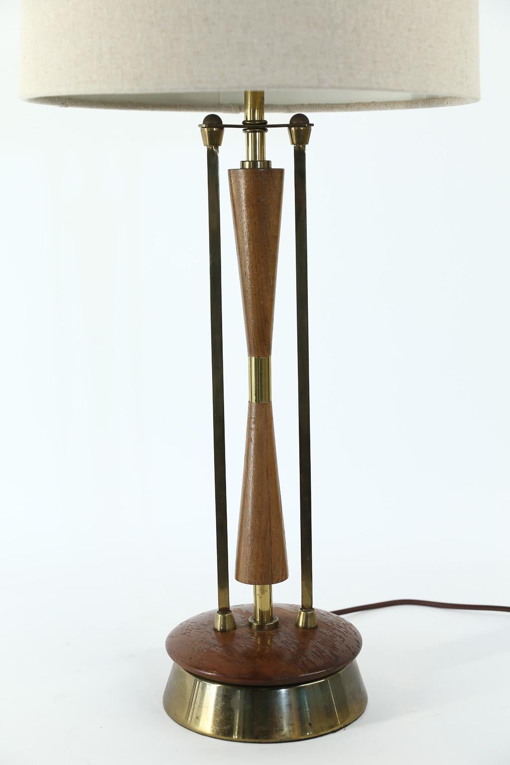 This midcentury wood and brass table lamp has been newly wired to meet United States standards. The lamp has a beautiful organic look. The new shade is included and dimensions are: 14