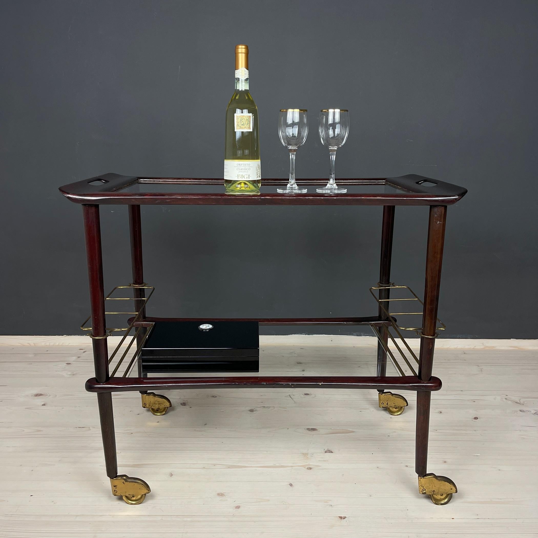 Indulge in the elegance of Italian design with this exquisite wooden trolley, a creation by renowned Italian designer Ico Parisi for De Baggis in the 1960s. Adorned with graceful rounded lines, this piece embodies the quintessence of mid-century