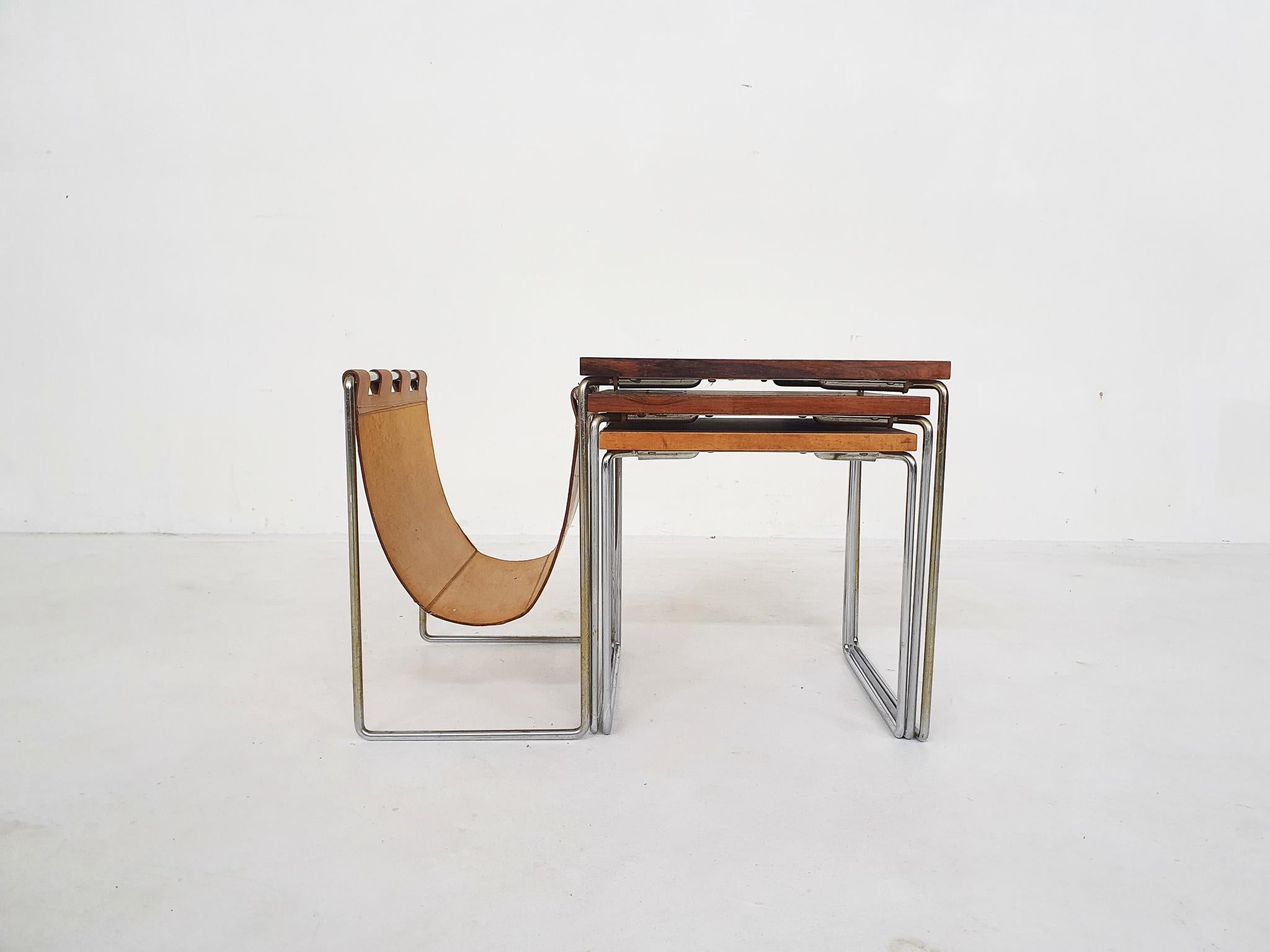 Mid-century wood and leather mimiset by Brabantia, The Netherlands 1950's.

Set of three wood veneer and metal nesting tables. The large one has a cognac saddle leather magazine rack.
The top has been refinished.
Large: 57 x 34.5 x 38cm