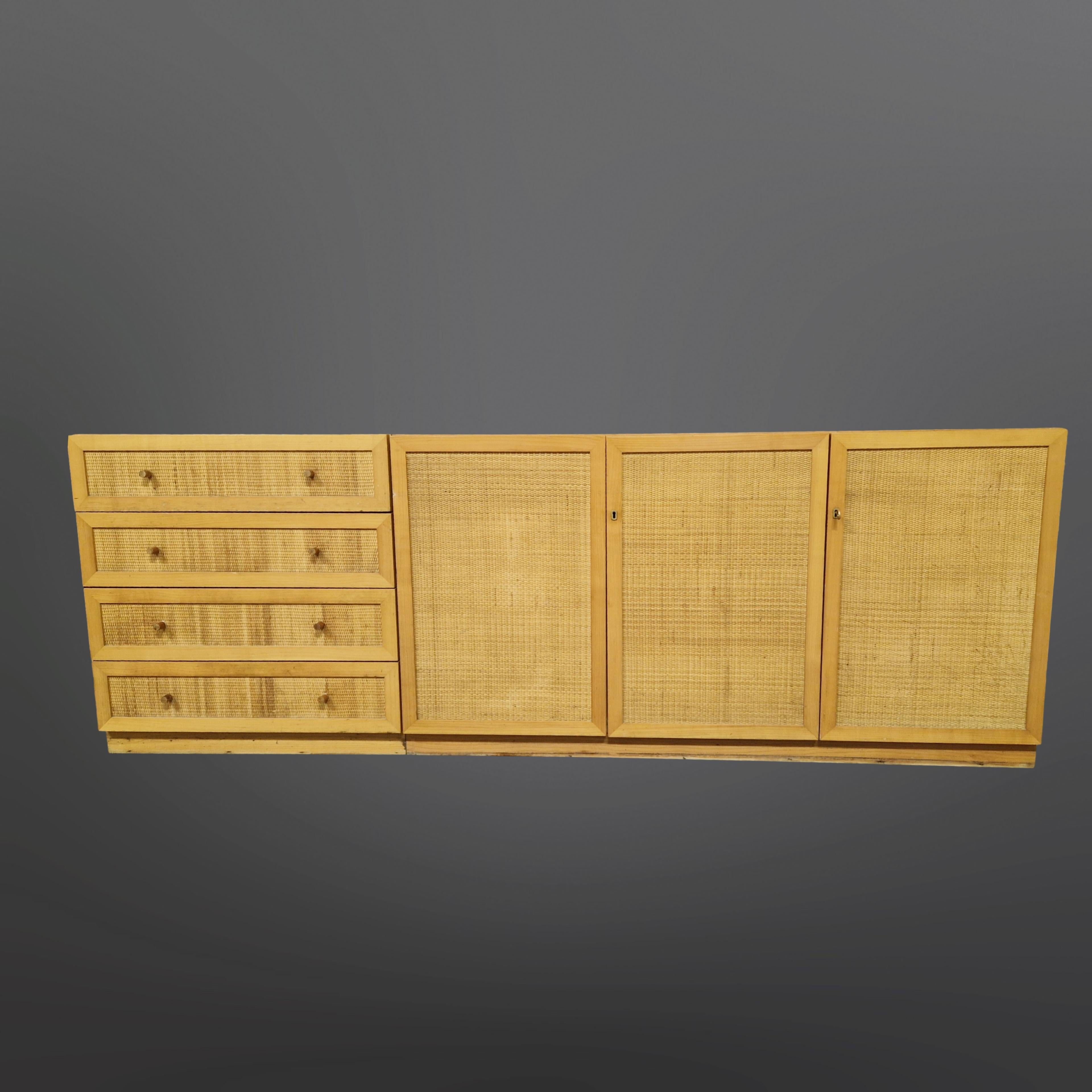 Modular light wood sideboard. It consists of 2 pieces that can be joined as one large sideboard or separately. They measure 75 and 150cm in width. One part with 4 drawers and one part with doors. Made from wood with rattan fronts on the doors and
