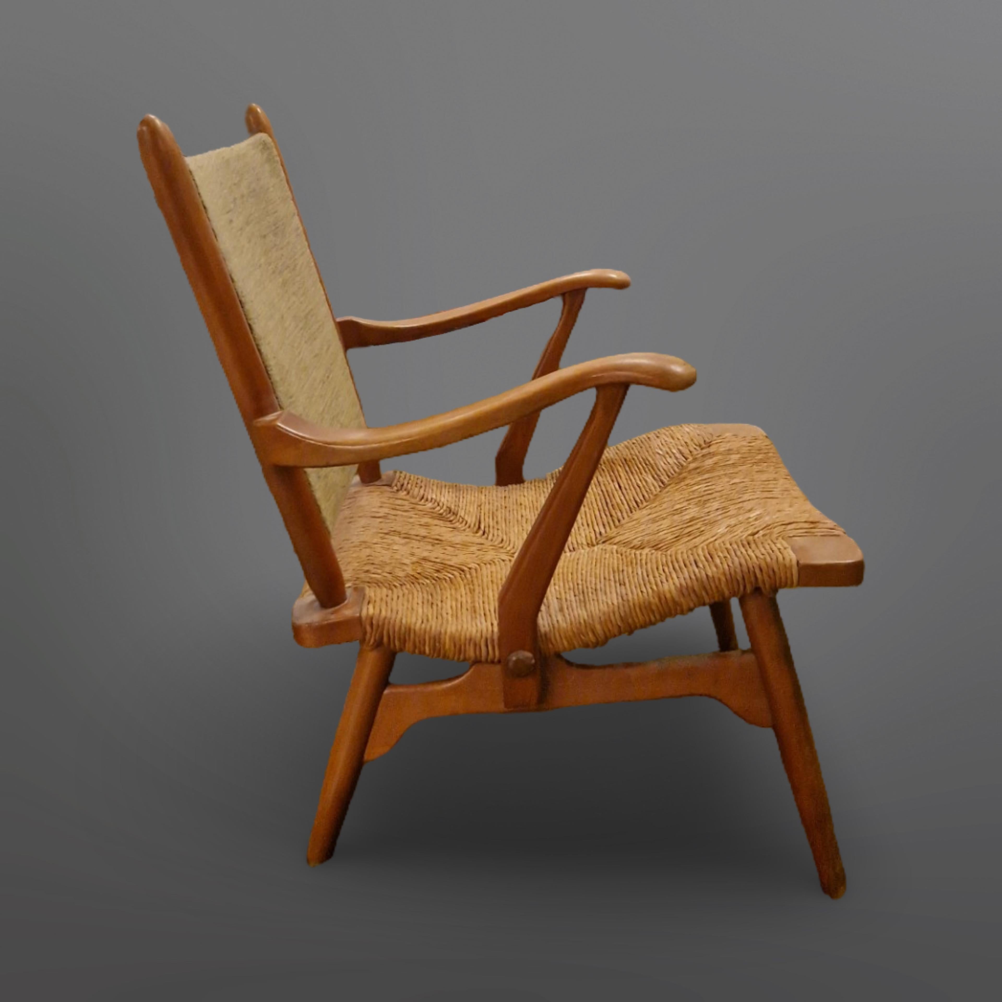 Early 1950s lounge chair. The frame is made from wood with a fabric upholstered back and hand woven rush seat. 
Made by Dutch company 