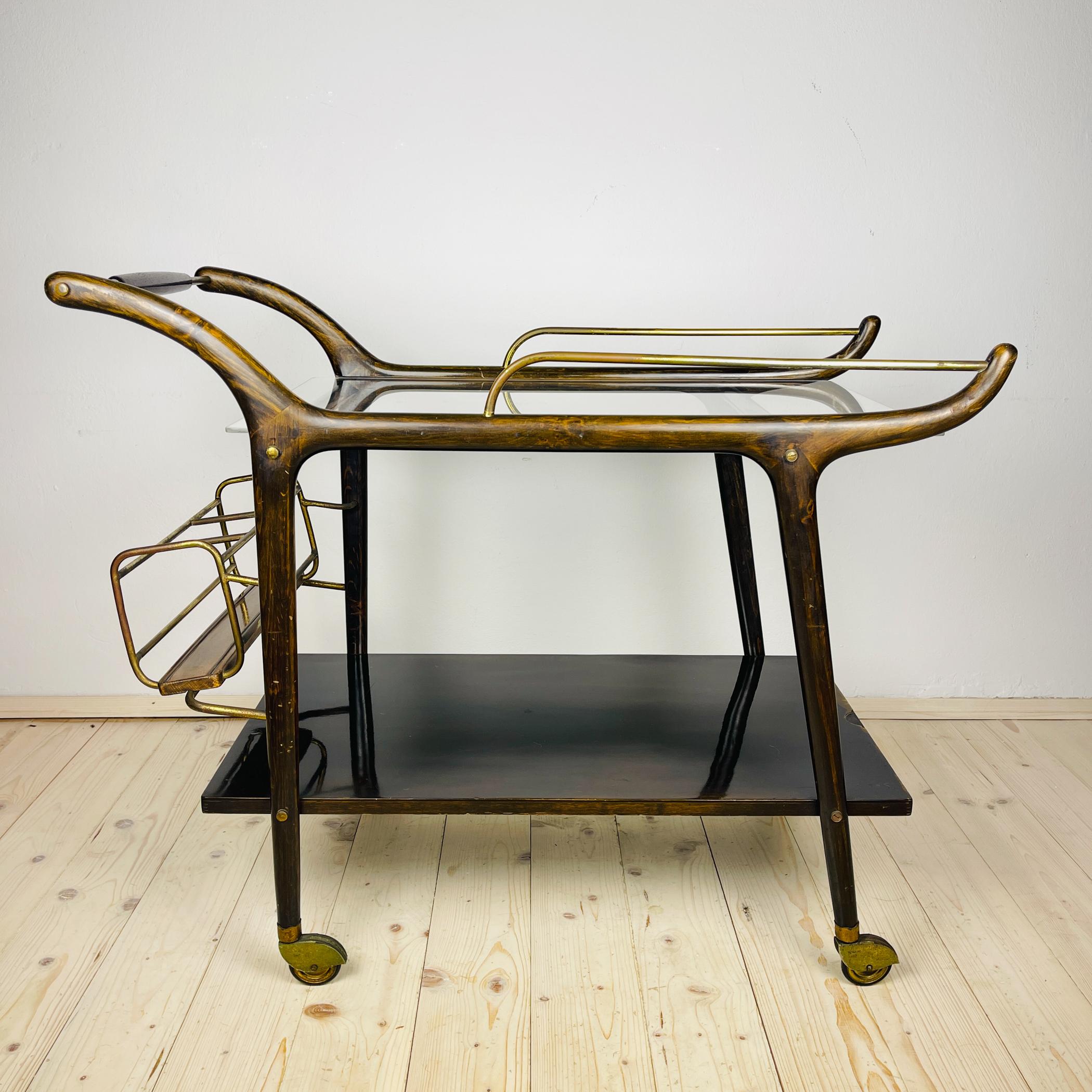 Chariot de bar en bois du milieu du siècle, fabriqué en Italie dans les années 1950.
Bois brun foncé, verre en plastique, tubes en laiton.

Bon état vintage.

Dimensions :
Largeur : 90 cm
Hauteur : 76 cm
Profondeur : 48 cm

Nous offrons un service