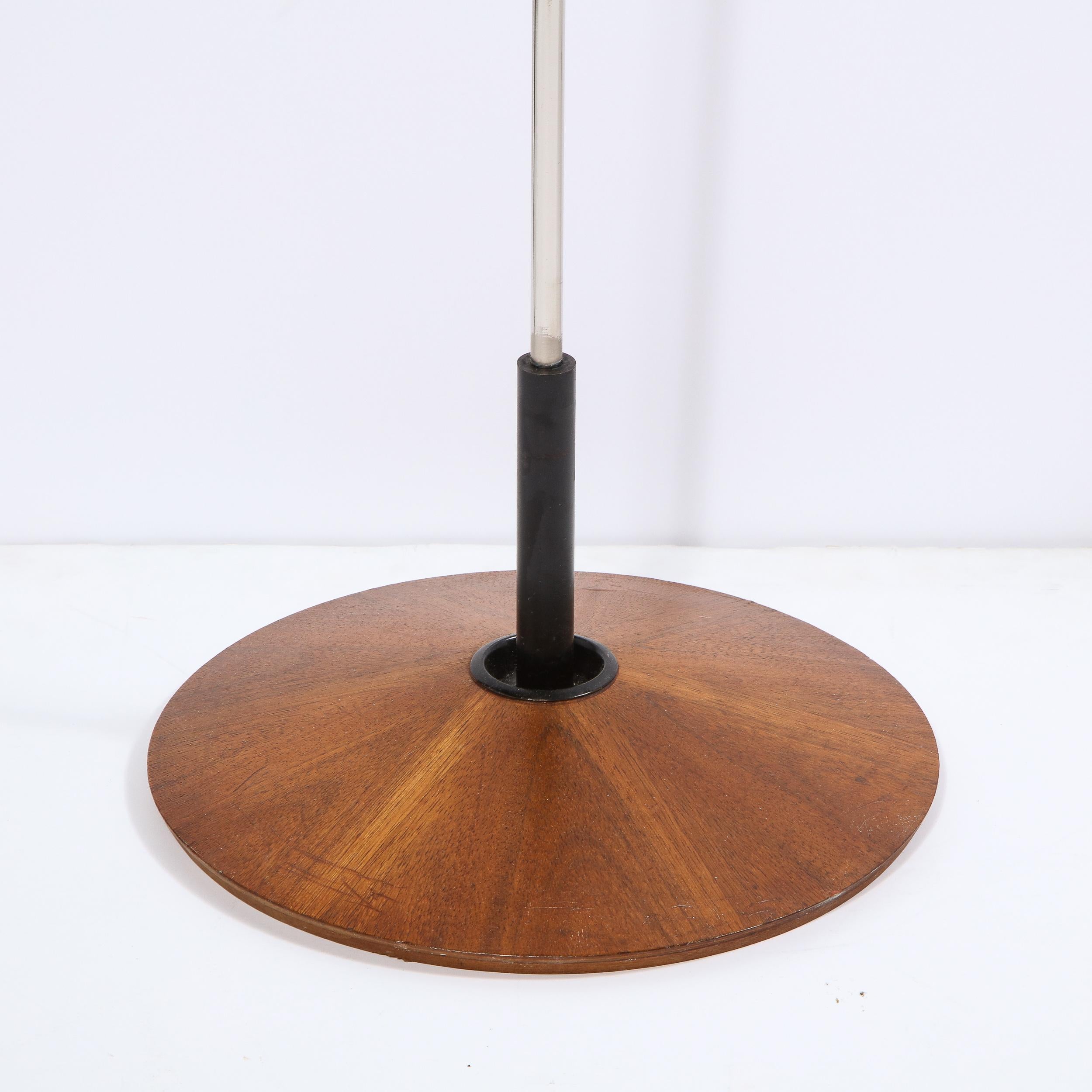 This refined Mid-Century Modern rosewood and chrome floor lamp was designed by Georges Frydman for Temde Leuchten in Switzerland, circa 1960. The piece offers a bookmatched rosewood veneer circular base from which a cylindrical chrome body ascends