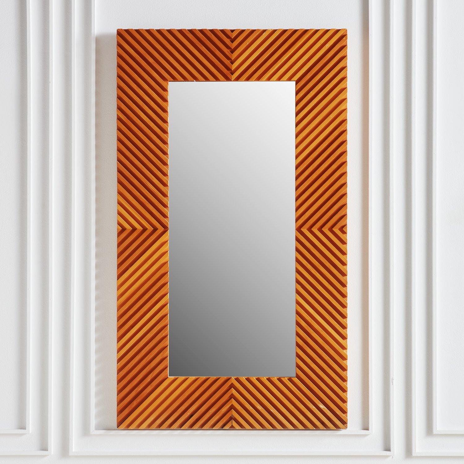 A gorgeous Mid century rectangular wall mirror by Greg Copeland, 1973. This mirror features a 7” wide wooden frame with a raised linear geometric pattern, reflective of Copeland’s signature op art style. The natural variances in the wood give this