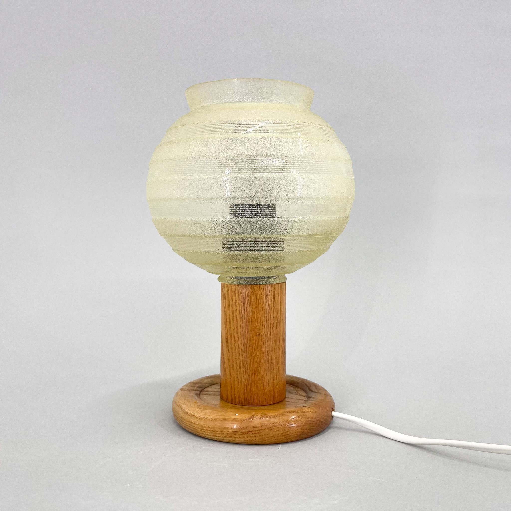 Lampe de table ou de chevet vintage, composée d'une base en bois et d'un abat-jour en verre. Produit dans l'ancienne Tchécoslovaquie dans les années 1970. Ampoule : E25-E27.