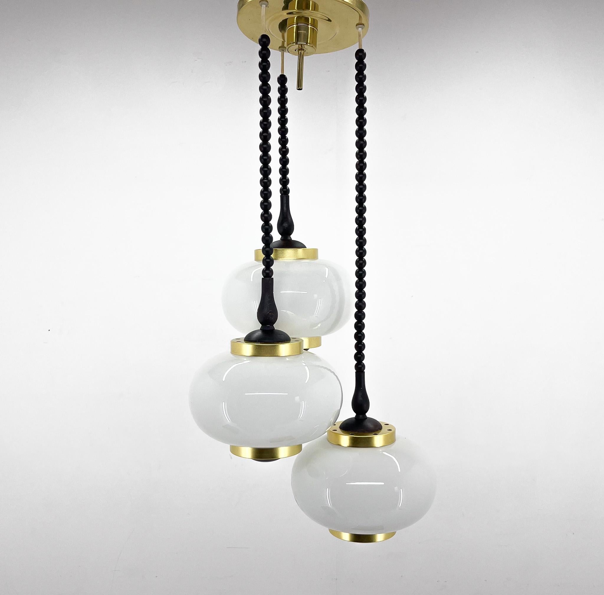 Vintage chandelier made in Poland in the 1970's by Polam Bielsko. Made of brass, metal, wood and milk glass.