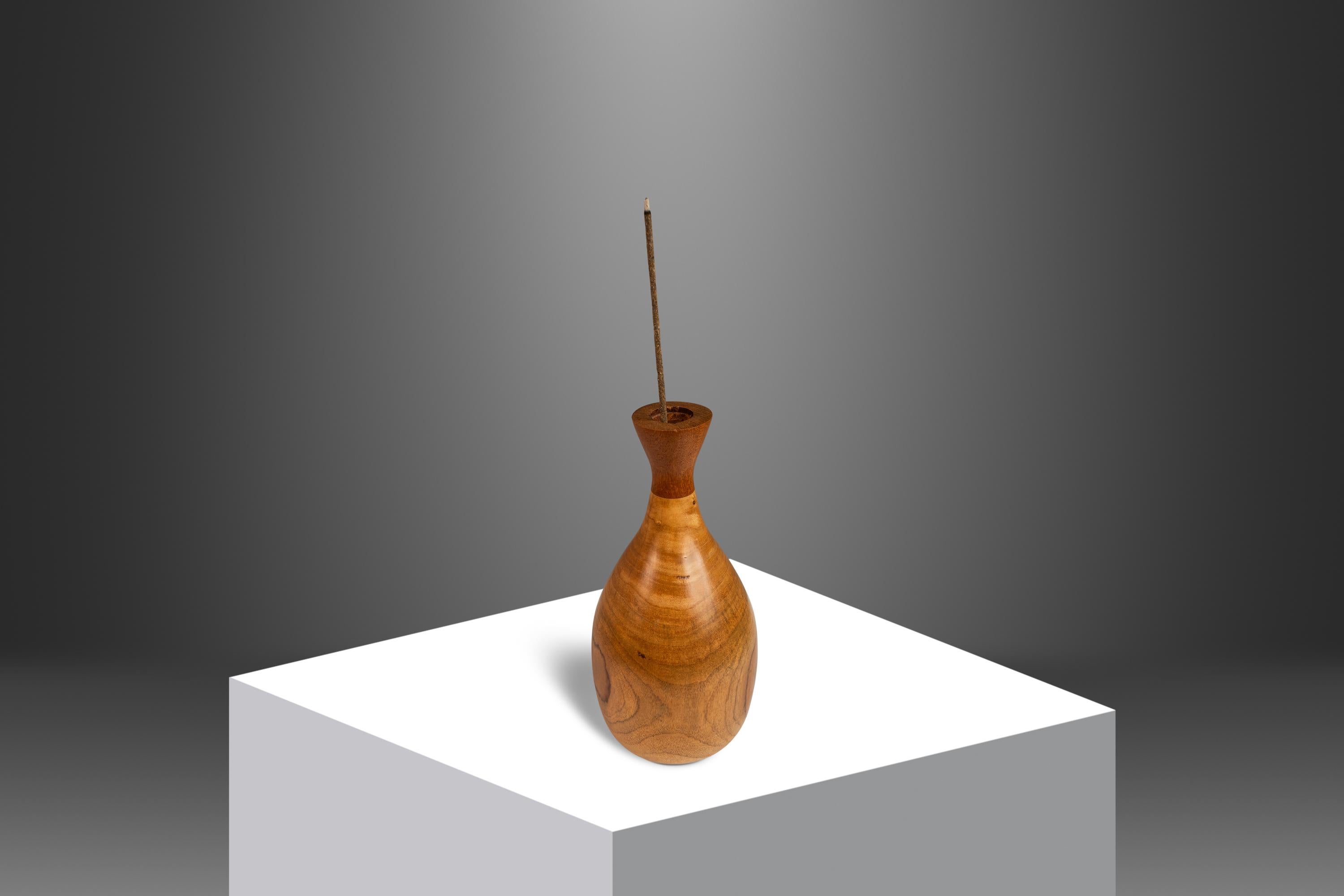  Introducing an artfully crafted Mid-Century Modern wood-turned vase hand-carved from a solid block of mesmerizing burlwood with out-of-this-world swirling woodgrains. The top piece is fashioned from a solid block of Burmese teak offering a unique