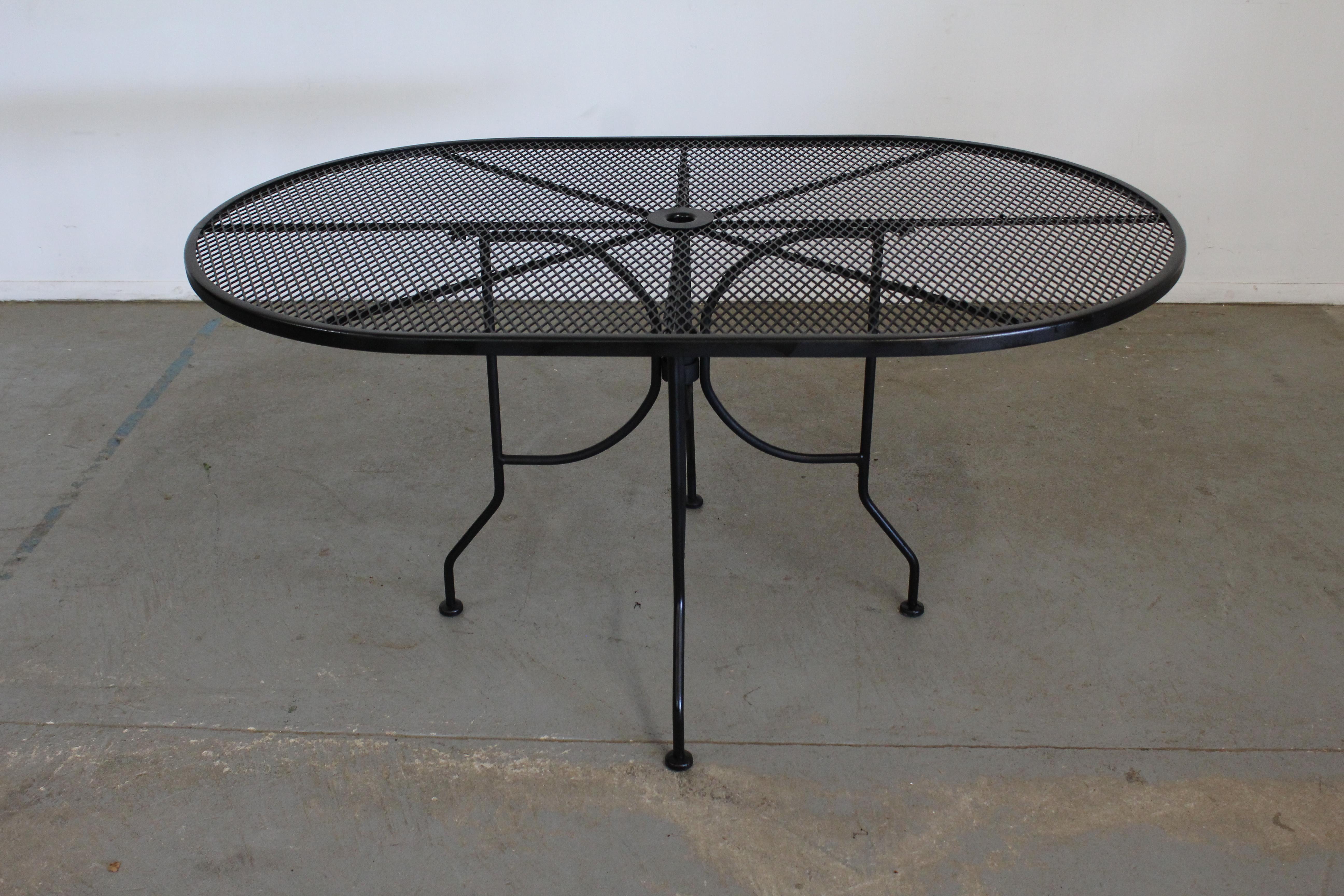 Mid-century outdoor iron woodard oval dining table.
Offered is a mid-century outdoor iron oval table. Features black paint and woven wrought iron. The table is structurally sound in good condition and can accommodate up to 6 seats. Has been