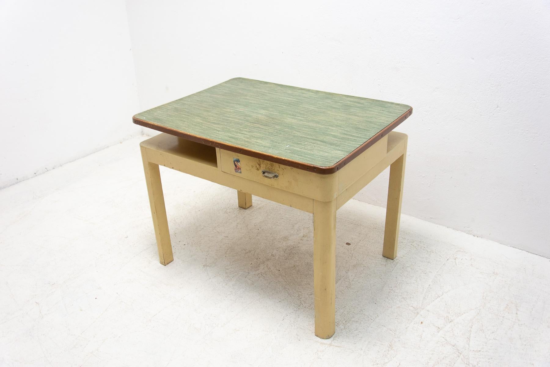 Mid century side table with one drawer. It was made in the former Czechoslovakia in the 1950´s. The table is made of wood and formica and painted in ivory. Overall is in good Vintage condition, shows signs of age and using.

Measures: Height: 74