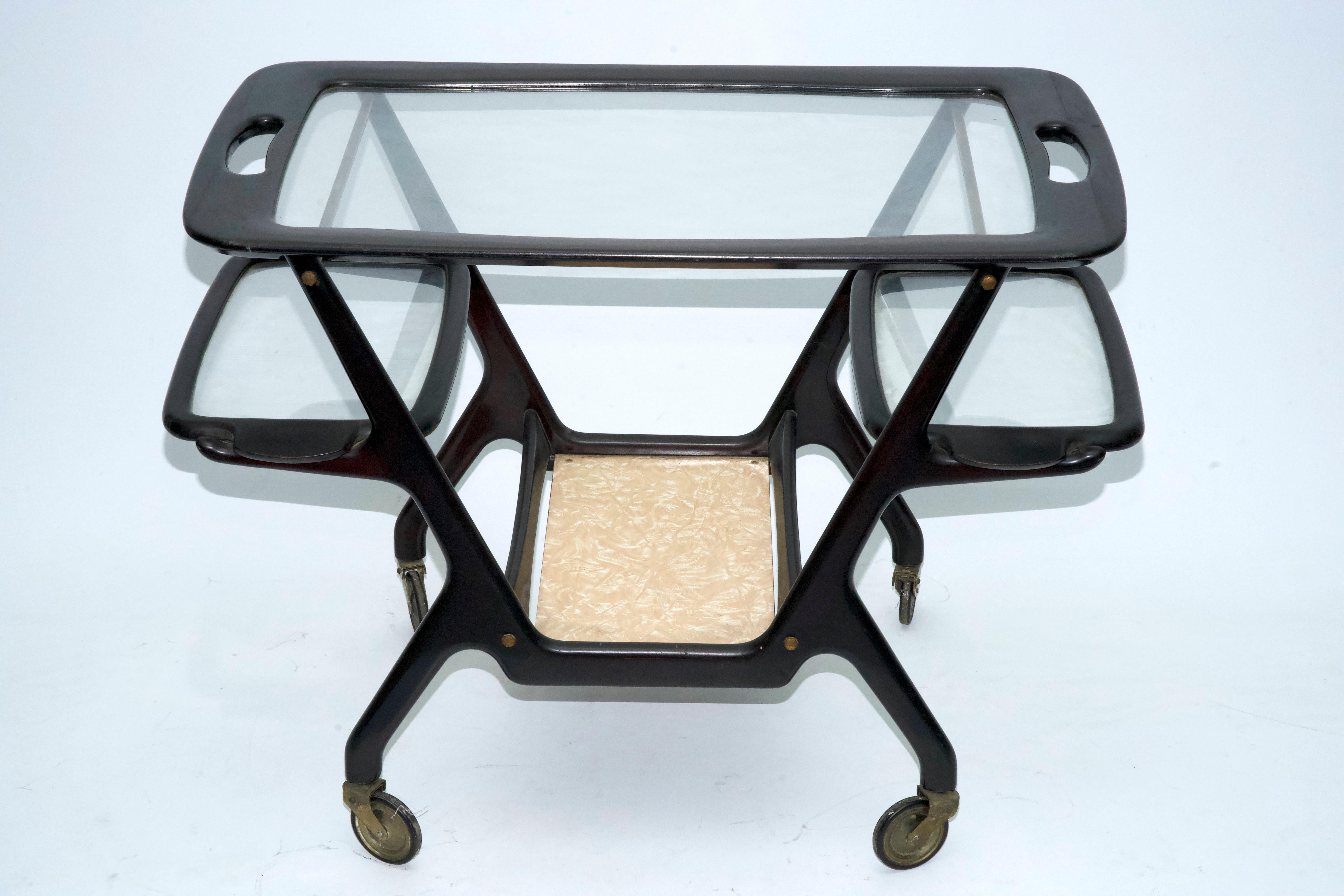 Chariot de bar italien sophistiqué conçu par Cesar Lacca, fabriqué dans les années 1950. La structure est faite de bois magnifiquement façonné, mettant en valeur les lignes organiques et l'artisanat élégant qui sont la signature d'Eleg. Il est doté