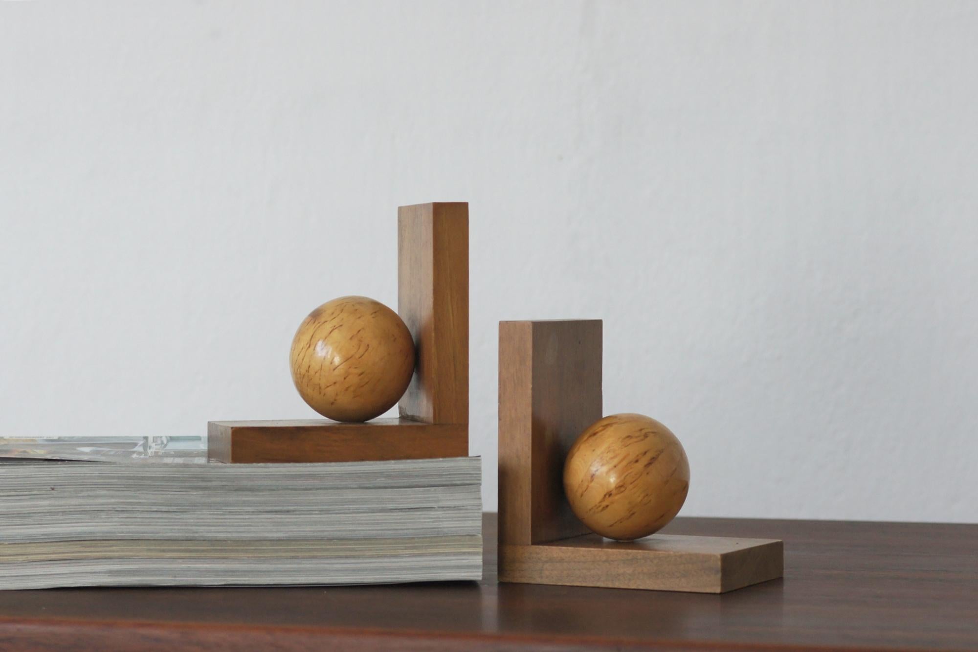 An exquisite pair of Art Deco style bookends, crafted from solid wood , showcases a bold geometric design with sculptural spherical accents. The rich grain of the wood accentuates their warmth and elegance, making them a timeless addition to any