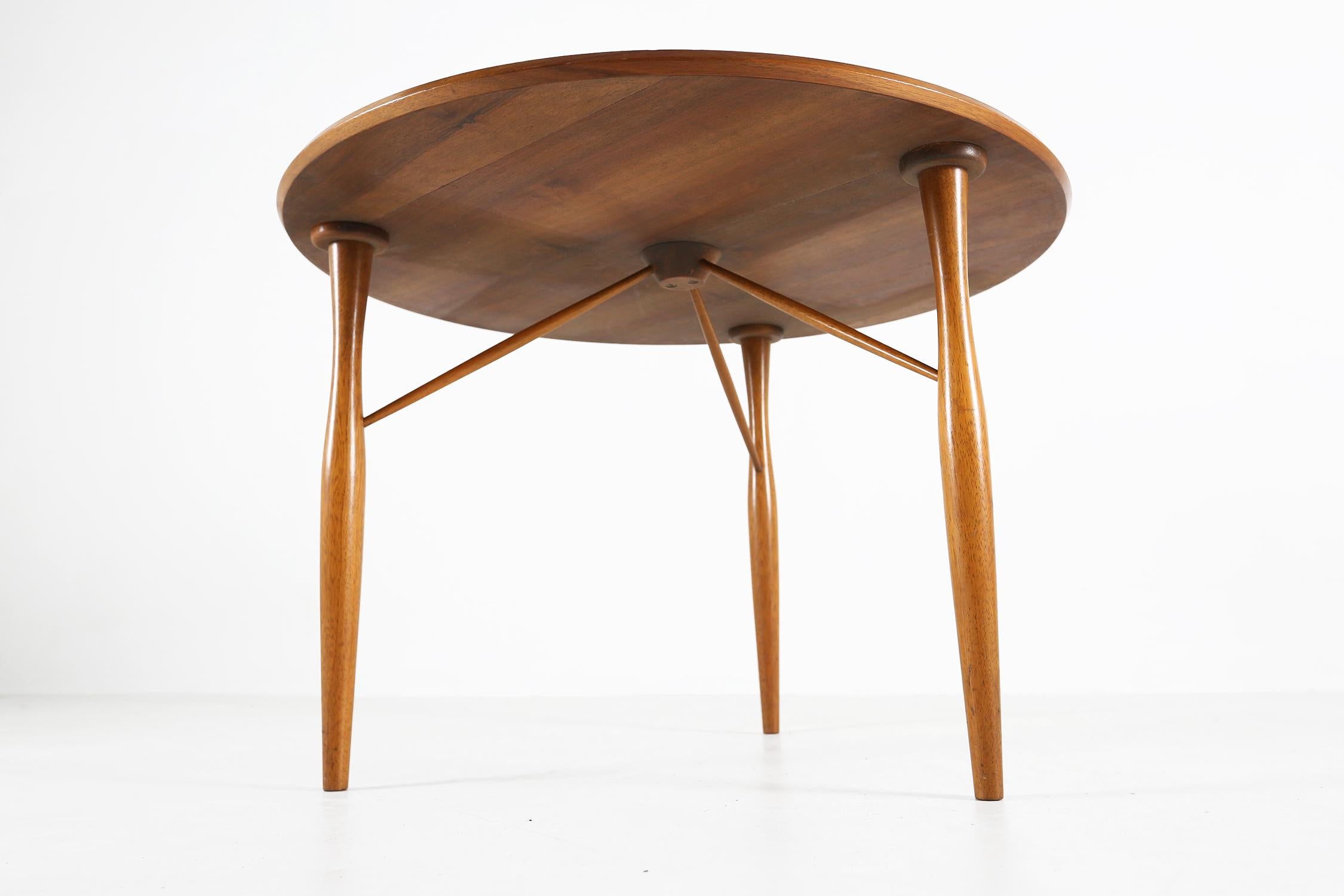 Cette petite table ronde est dotée d'un plateau en bois, ce qui en fait un meuble robuste et durable. Le design du milieu du siècle ajoute une touche d'élégance à tout espace de vie, tandis que sa taille compacte en fait une table basse idéale dans