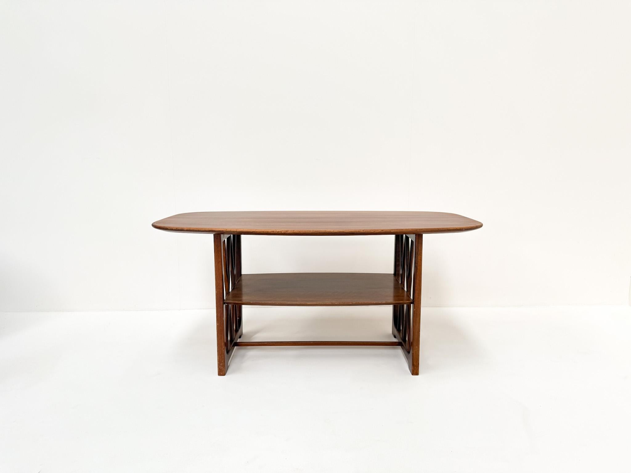 Una llamativa mesa de centro de madera diseñada por A.A. Patijn para Zijlstra Joure en la década de 1950, probablemente parte de la serie Poly Z. La mesa luce detalles refinados, como los paneles laterales en forma de cruz y el delicado borde con