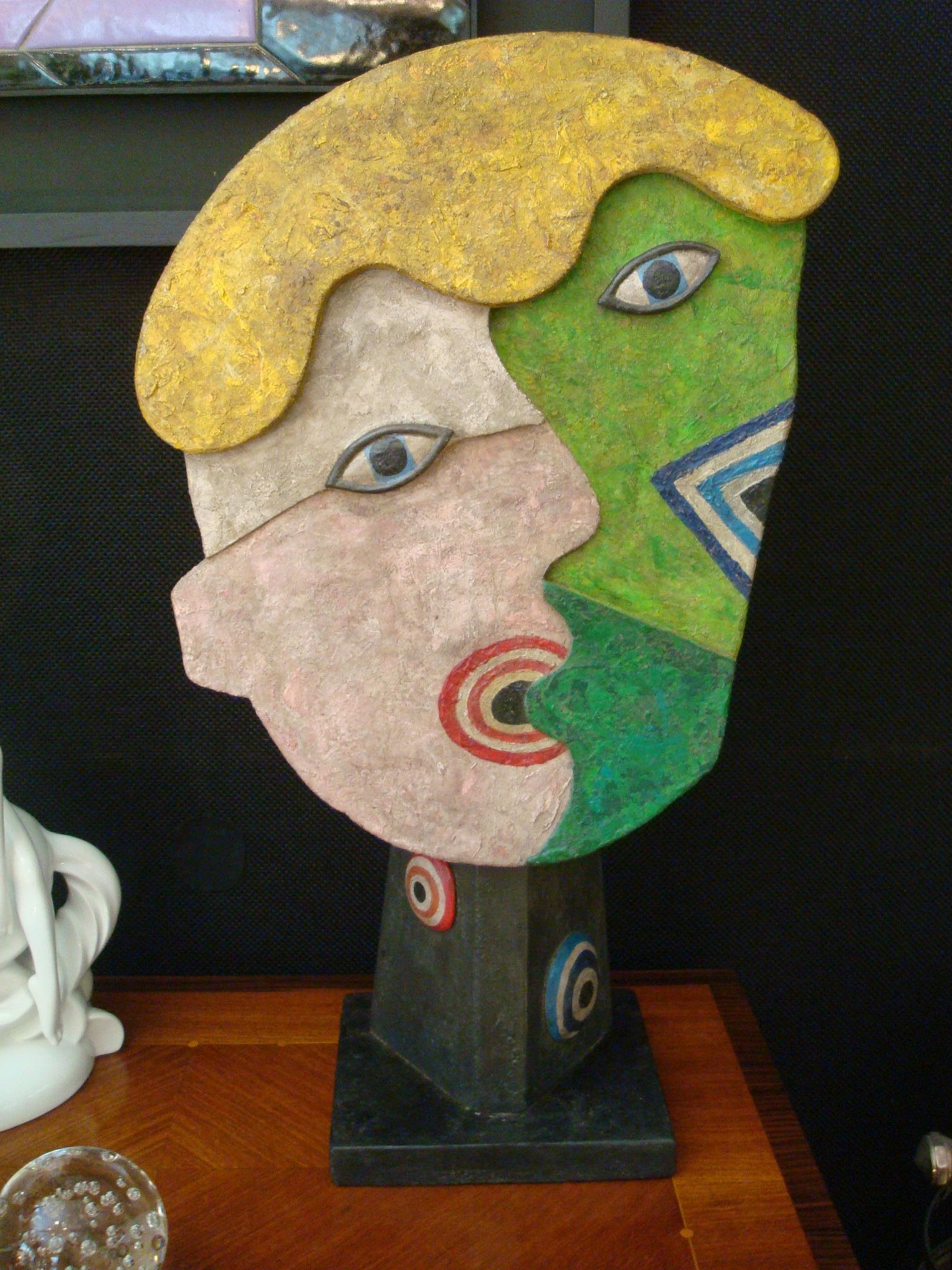 Painted wooden faces over a stand. Rare sculpture of the people talking. Nice colors. It has no signature.
It was bought to a french family, everything in the house was french made.
     