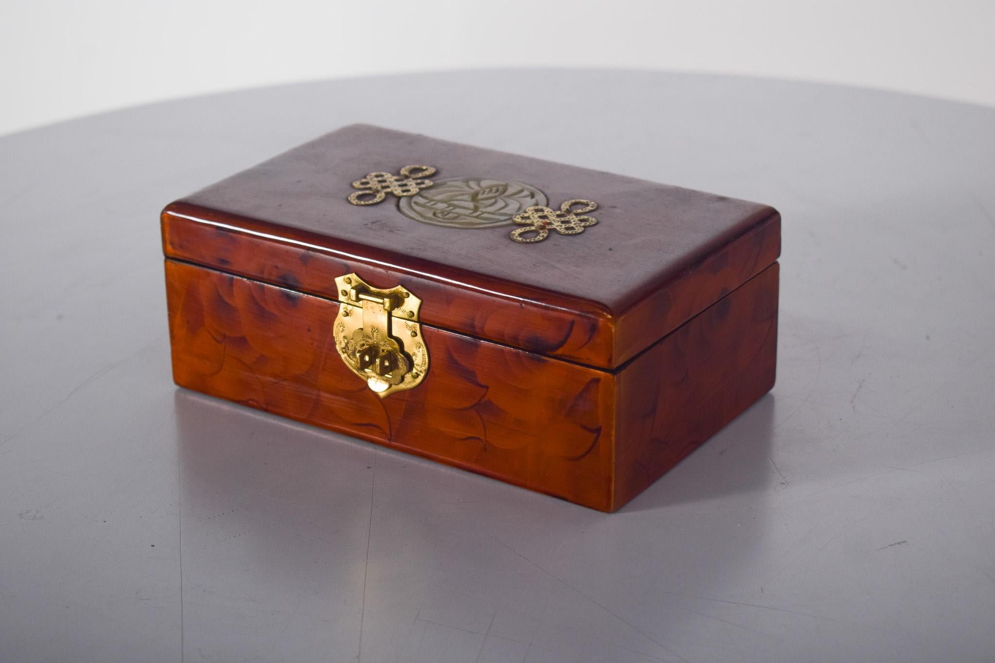 Joyero de madera. Precioso joyero, muy probablemente de origen portugués, de madera con efecto lacado.
Forrada interiormente con tela roja satinada y estampada con delicadas flores en relieve, con dos compartimentos diferentes, uno para anillos,