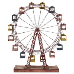 Ruota panoramica cinetica in legno e metallo di metà secolo con cabine rosse, blu e gialle