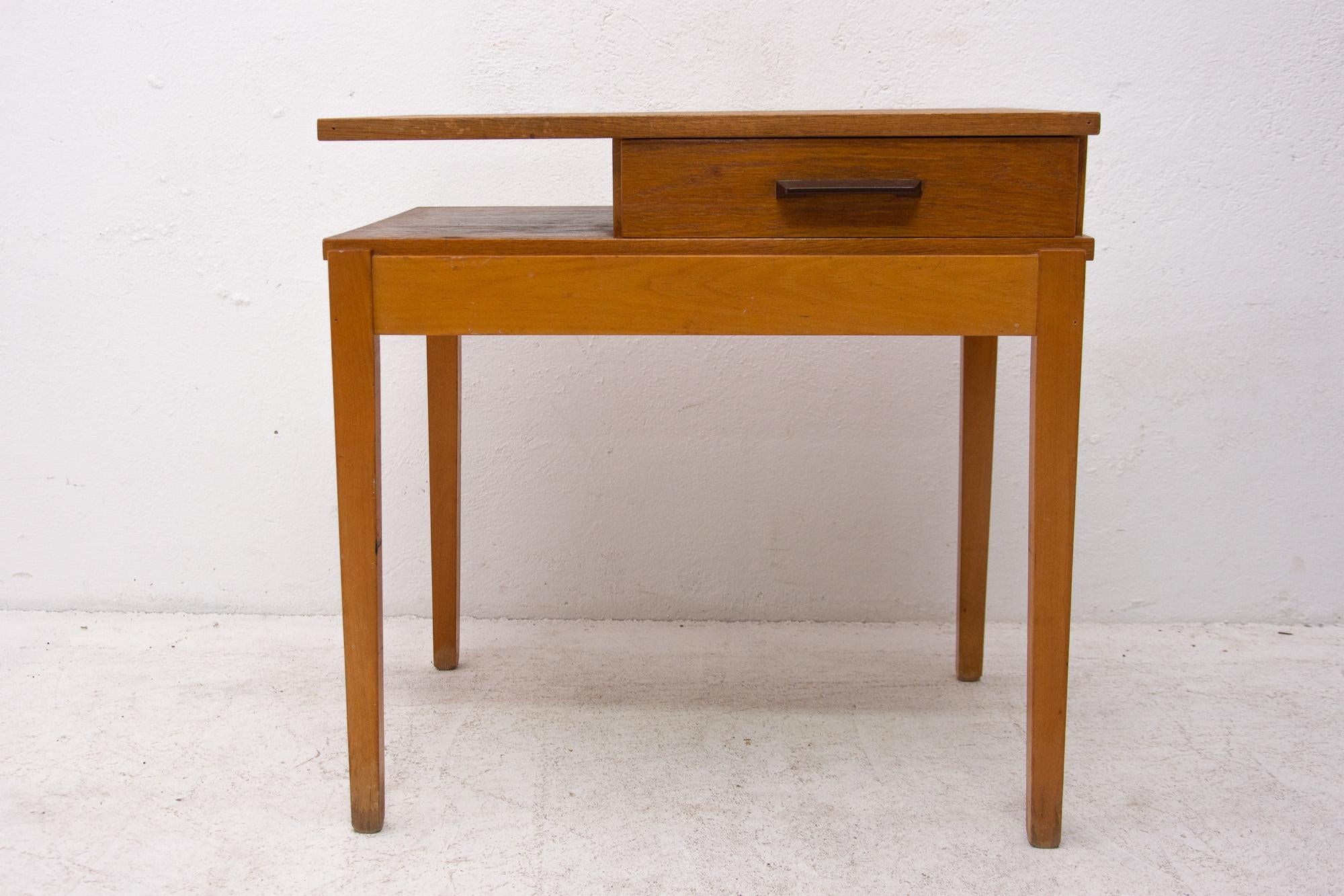 Midcentury side table with one plastic drawer. The table is made of beech wood and oak wood. At the top it shows signs of age and using. Overall is in preserved good Vintage condition. Cool retro piece.